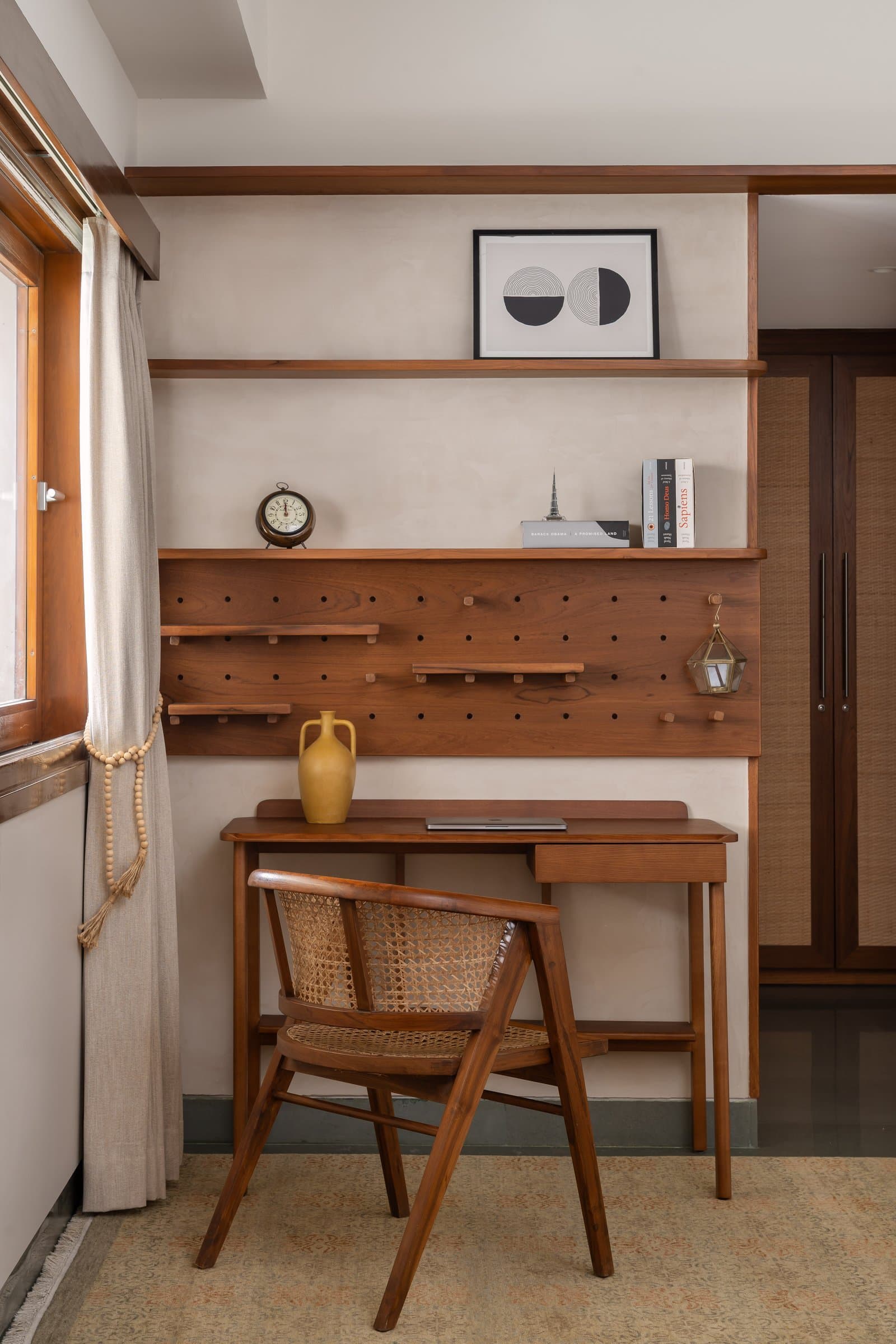 The master study nook: a custom timber pegboard wall and cane-back chair make the utilitarian quietly beautiful