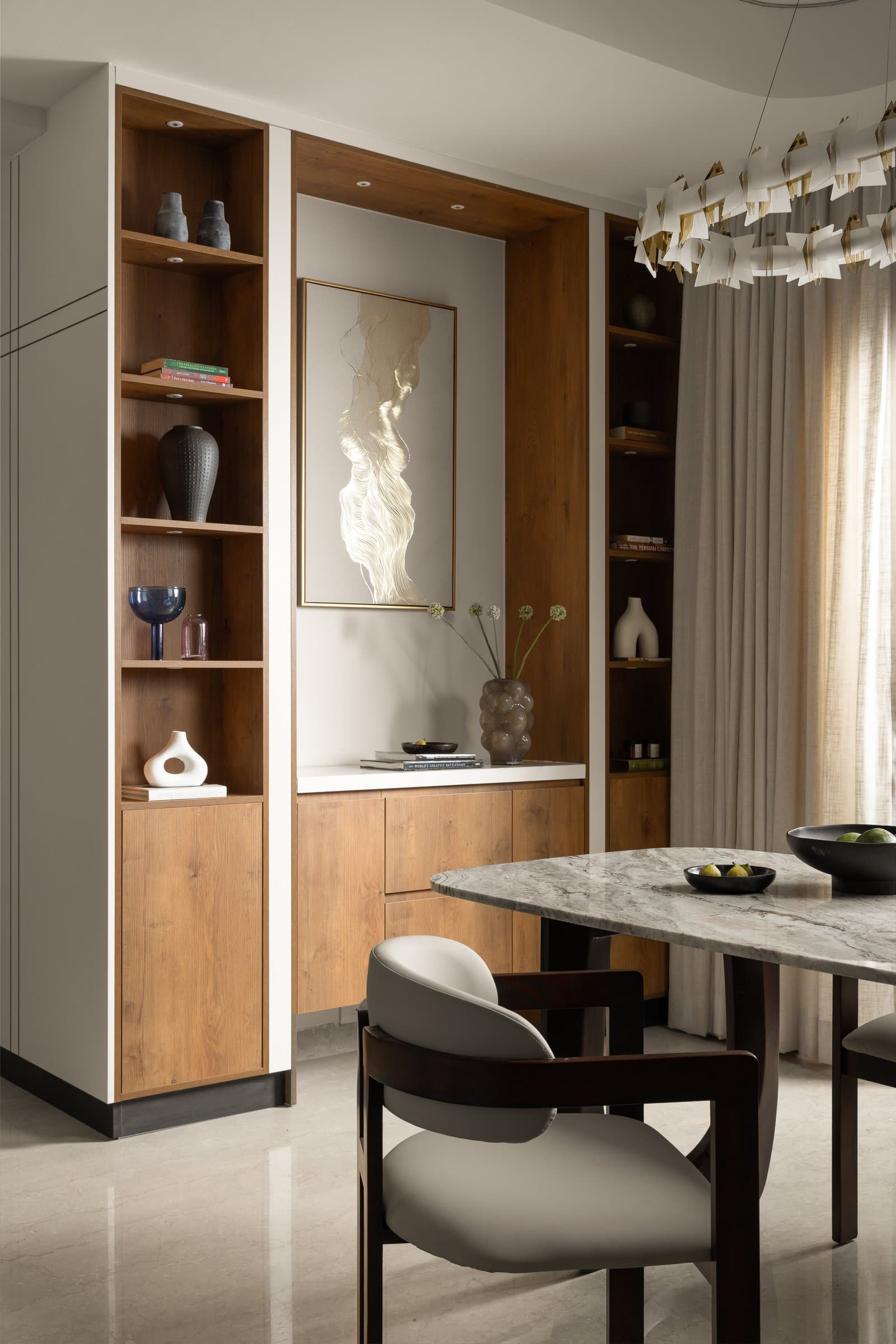 The dining wall unit, mediating between zones with open shelving and a consistent timber language