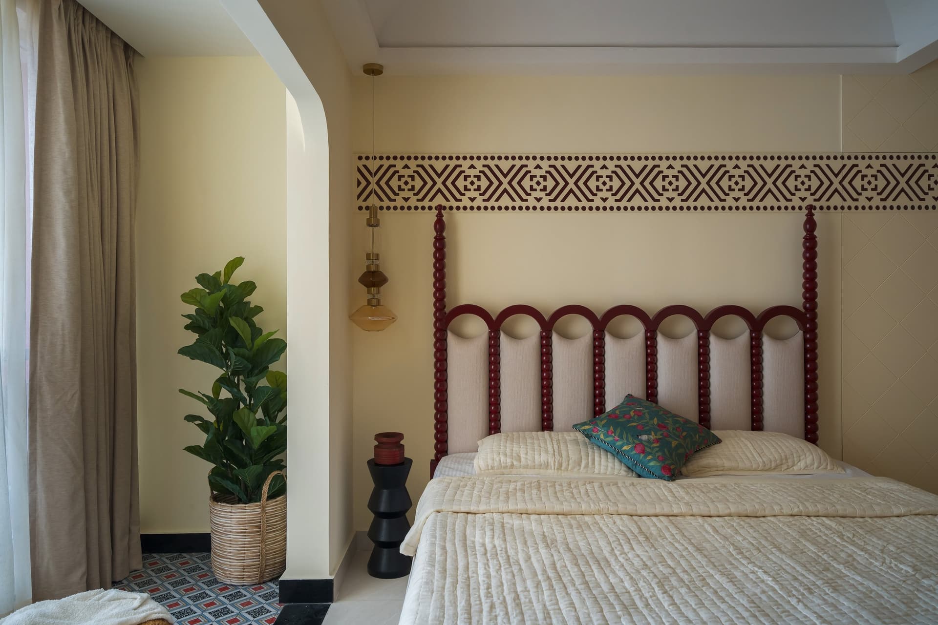 The master bedroom's custom headboard: turned maroon bobbin columns and arched upholstered panels reinterpret traditional Indian craft furniture
