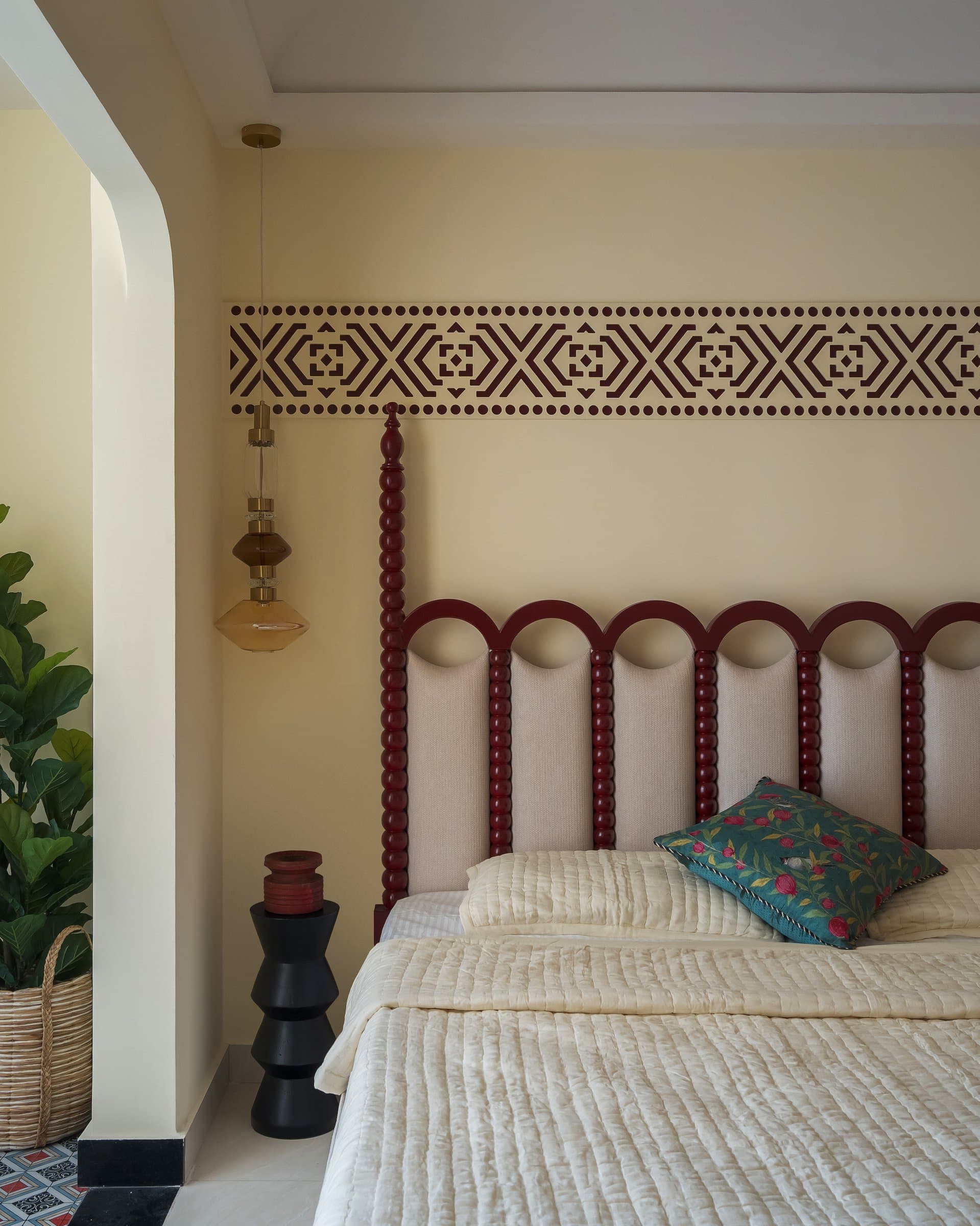 A closer view of the headboard's turned-column construction and the geometric wall border above