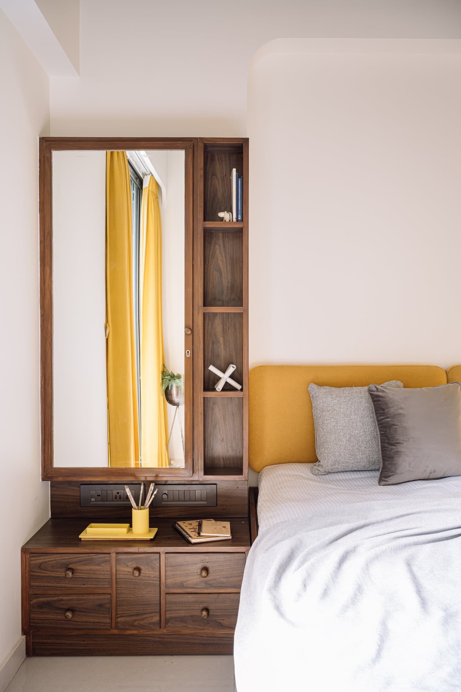 The guest bedroom, where mustard upholstery and dark walnut offer warmth with restraint