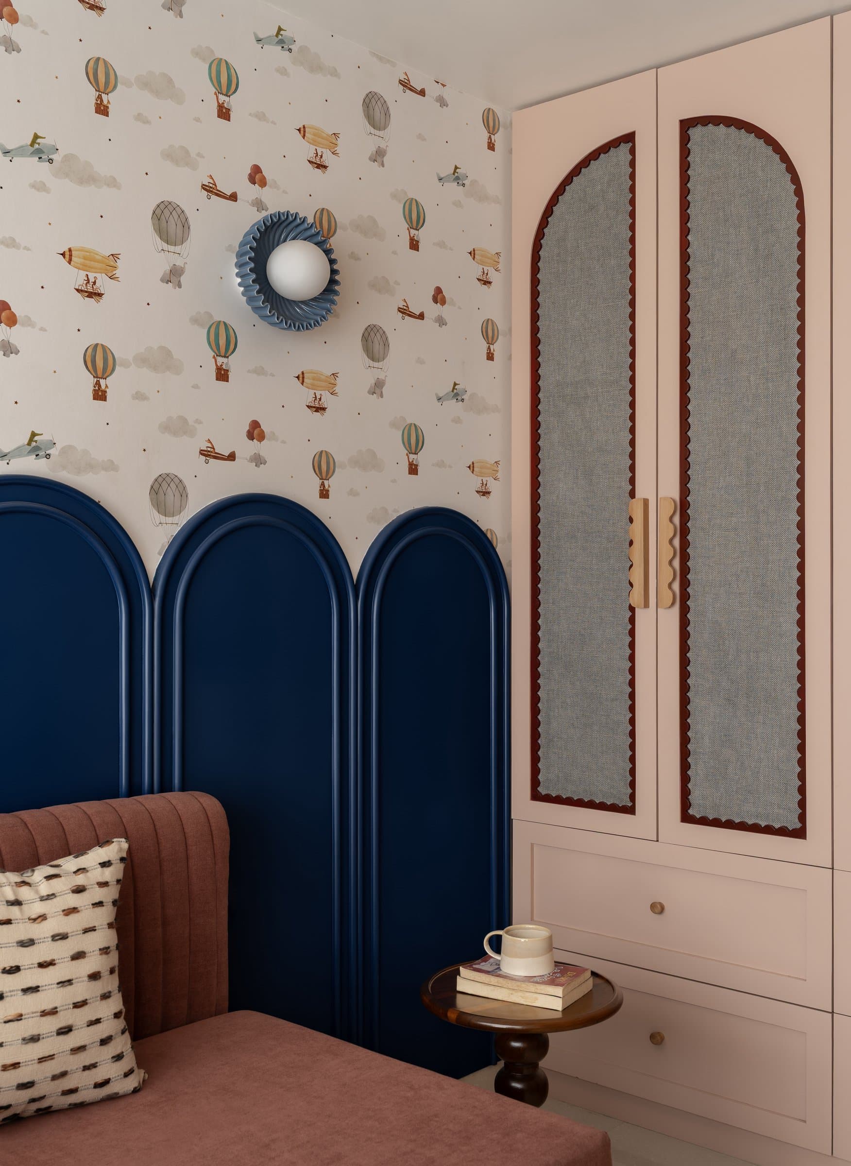 The children's room commits fully to character, with vintage-aviation wallpaper and a navy arched dado