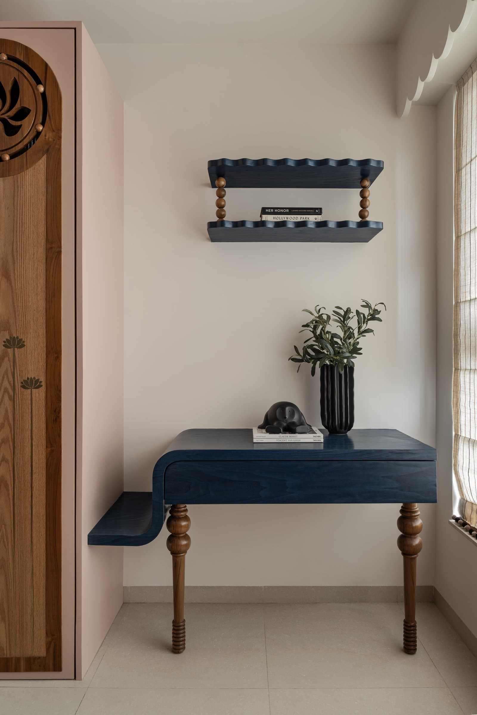 The bespoke desk meets a scalloped indigo shelf in the home's most colour-confident moment