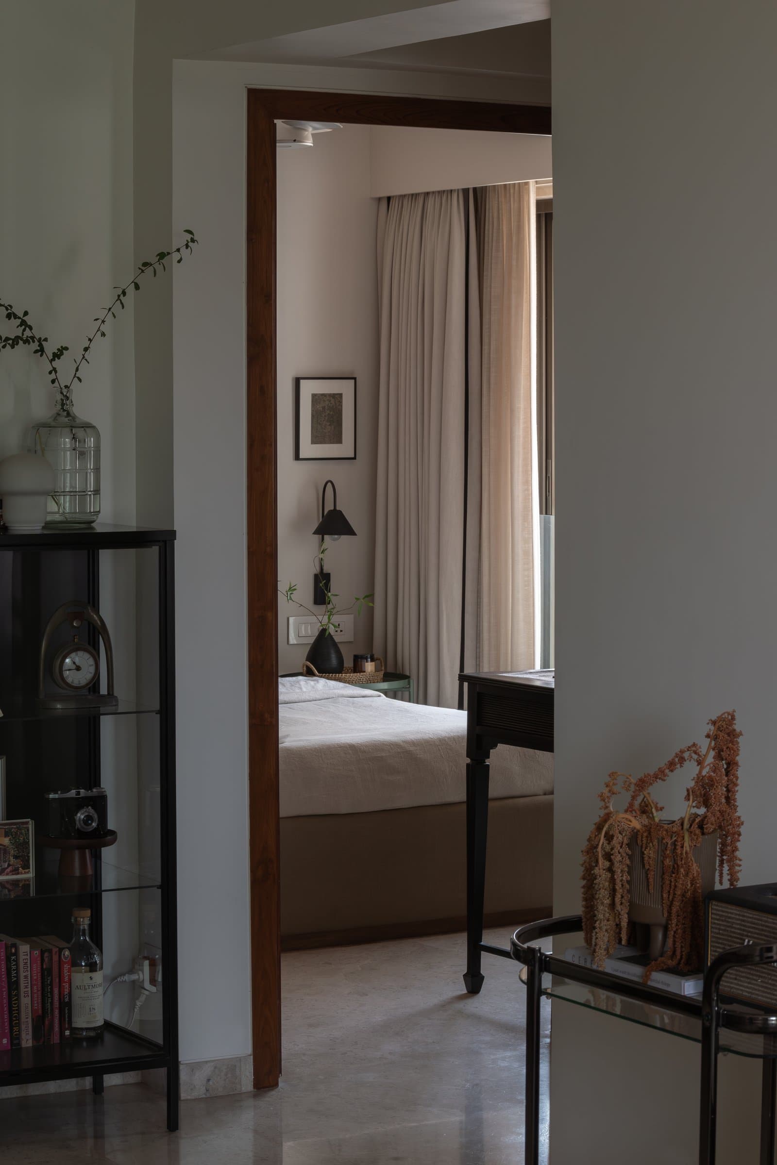 A view from the living room into the master bedroom, the home's spatial transitions handled as gentle dimmings of tone