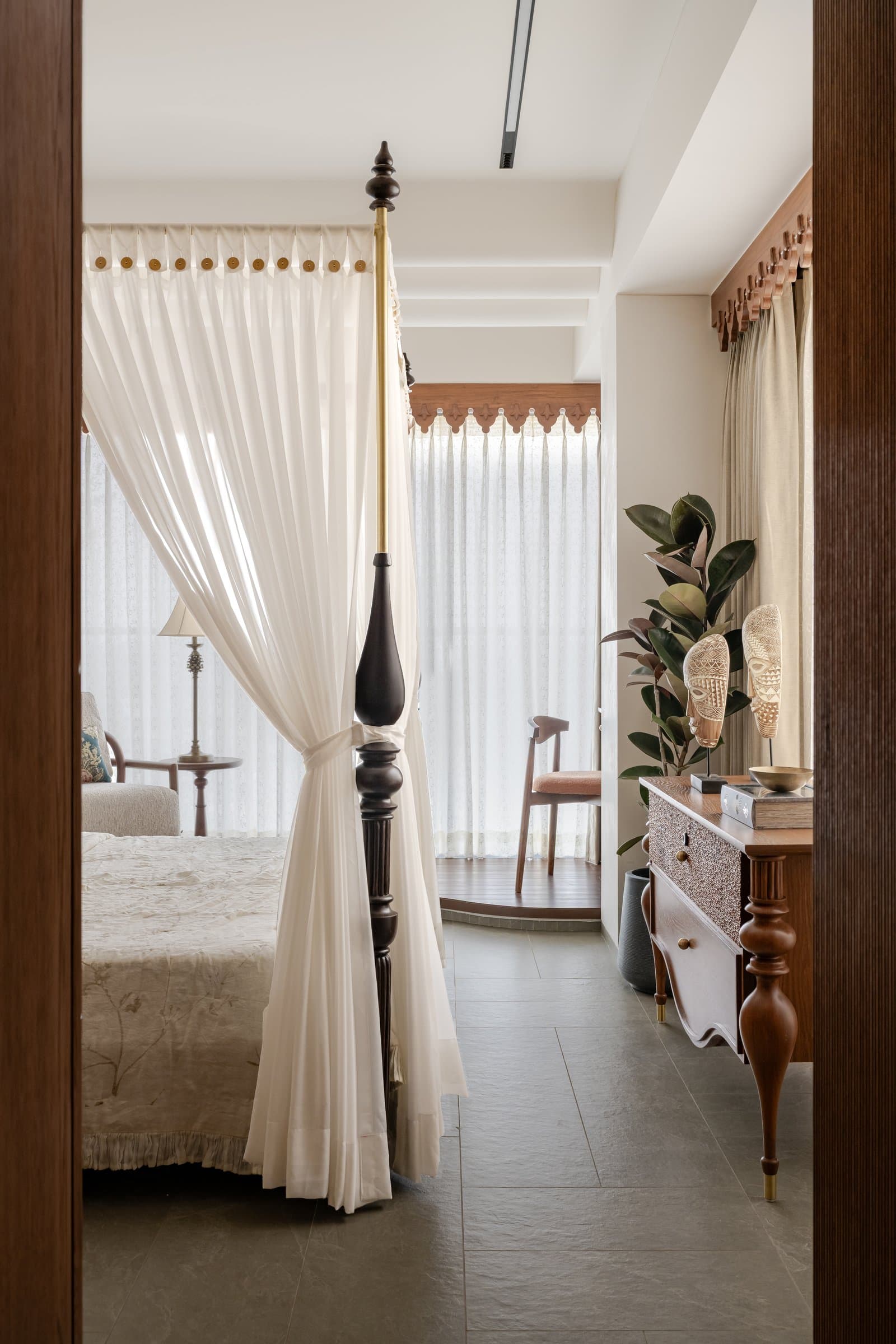 Wing B's master bedroom, a four-poster in dark timber and white curtains evoking colonial-era canopied beds
