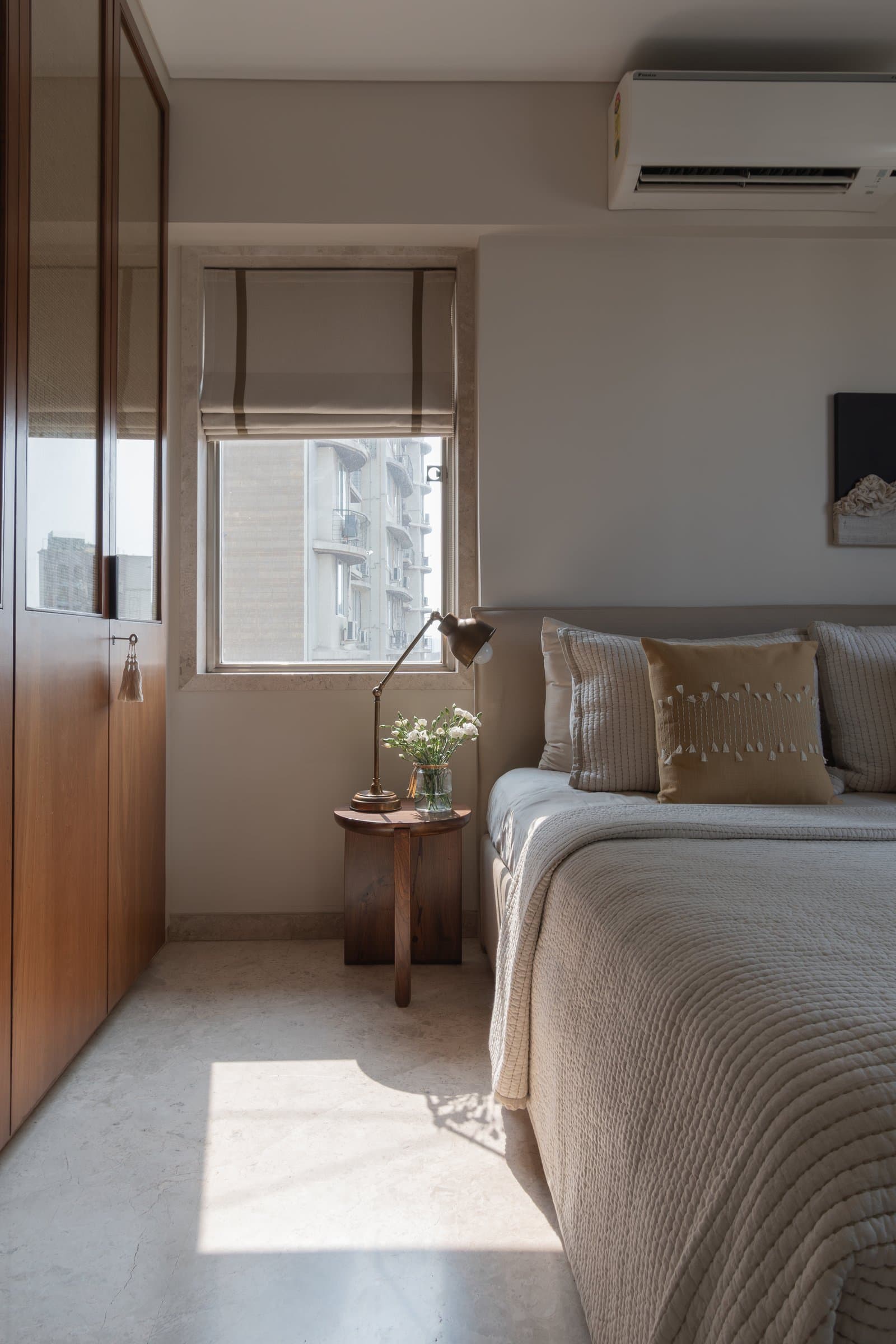 A wardrobe wall in honeyed wood with caned upper panels, the room's single decorative gesture allowed to stand alone
