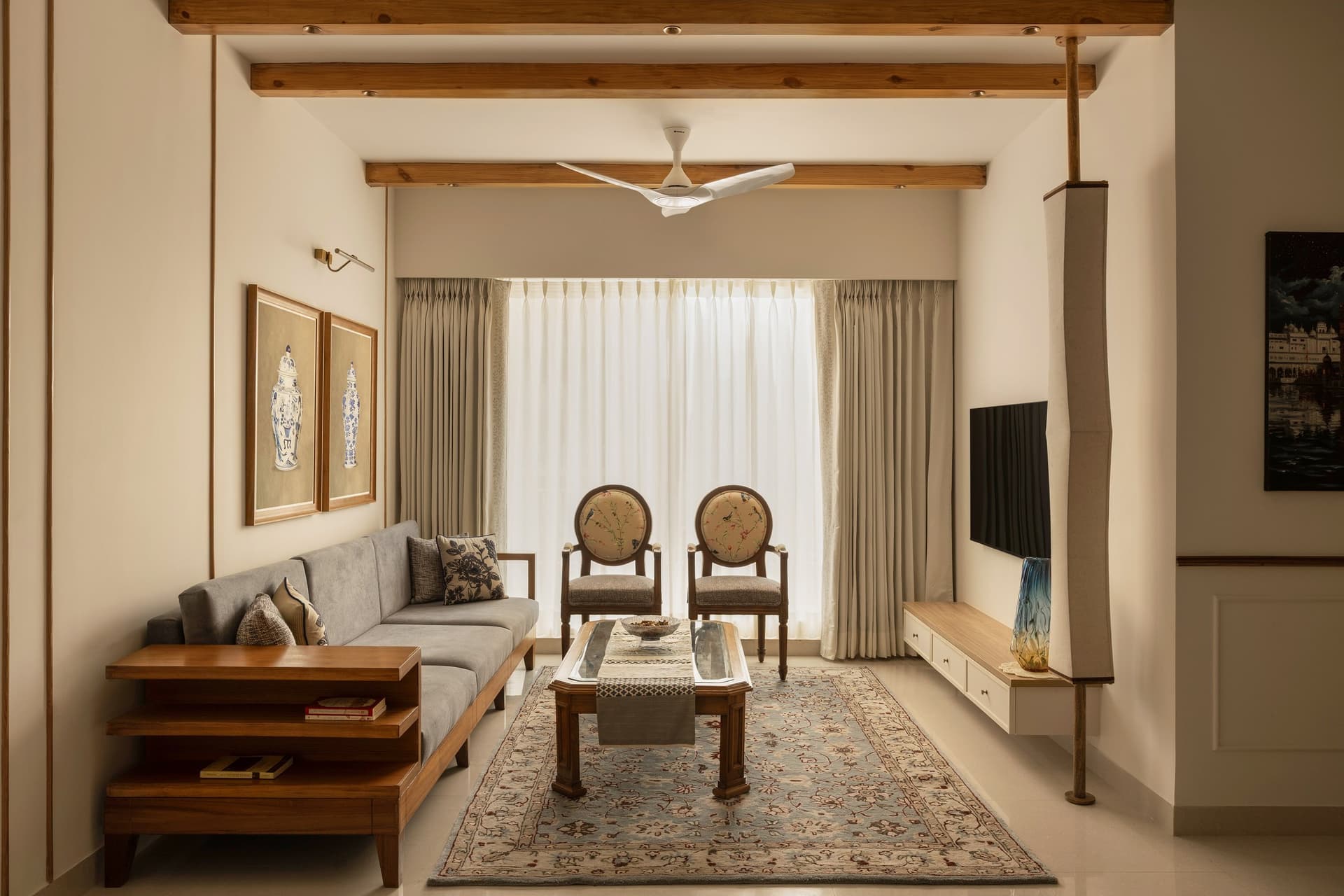 Timber ceiling beams and a carefully composed seating arrangement give the living room a sense of permanence