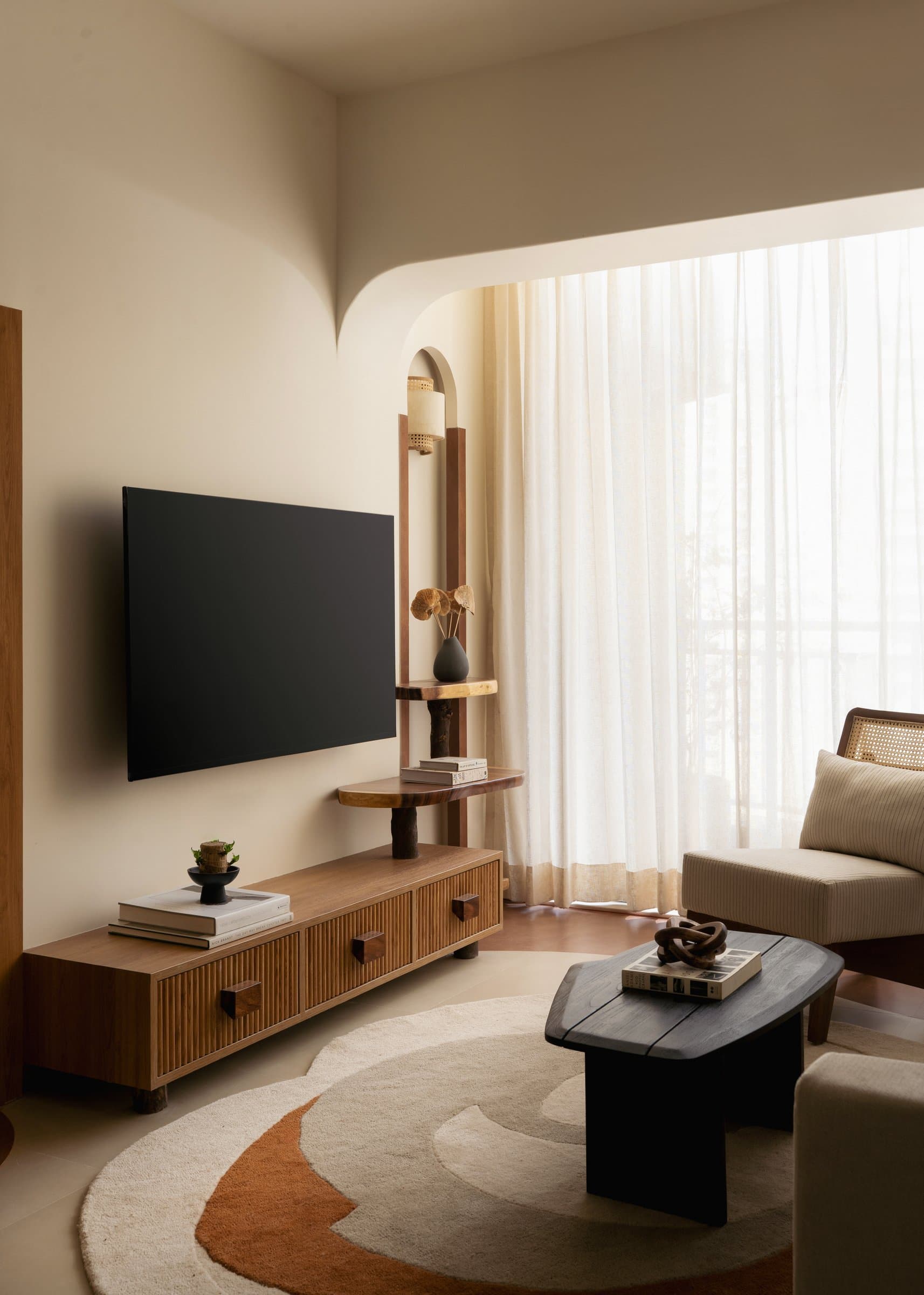 A slim timber étagère and fluted media console hold the corner with deliberate quiet