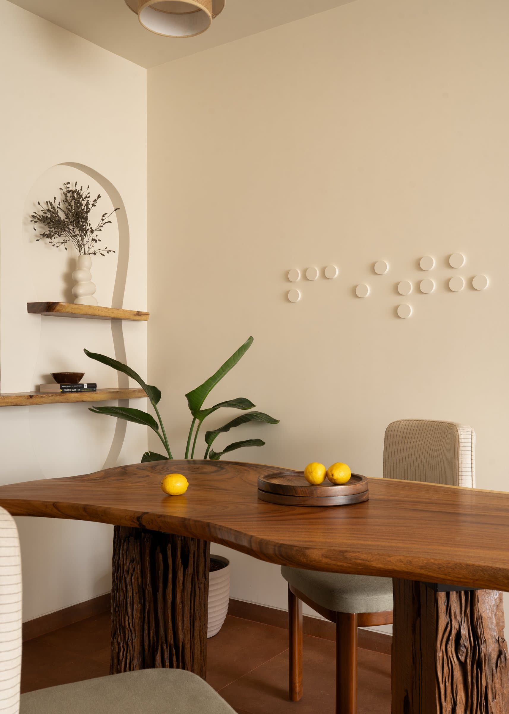 The dining table: a single figured timber plane on two retained-bark trunks, the home's ethos in one object