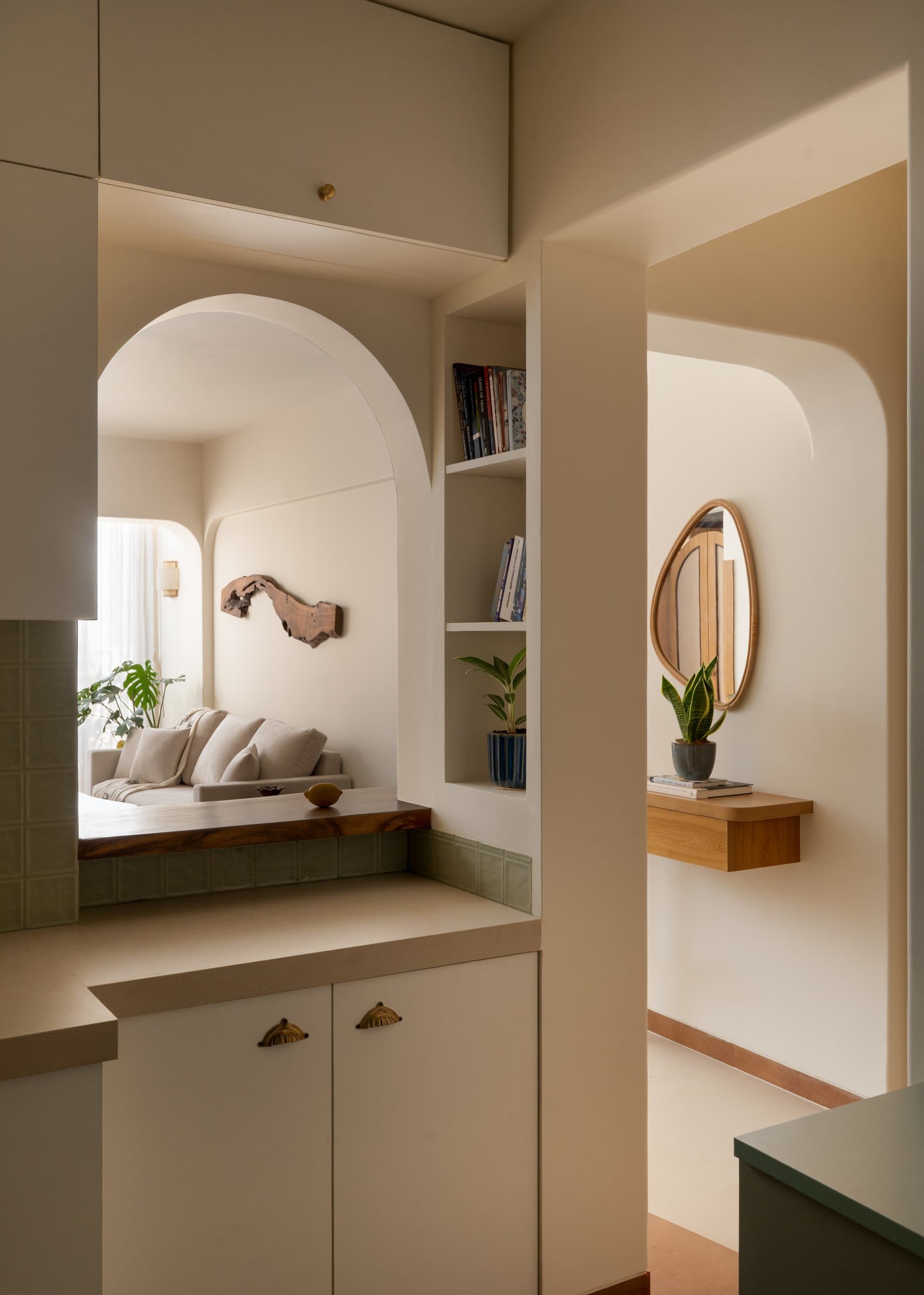 The most architecturally inventive moment in the plan: pass-through, bookshelf, and arched mirror in one tight square