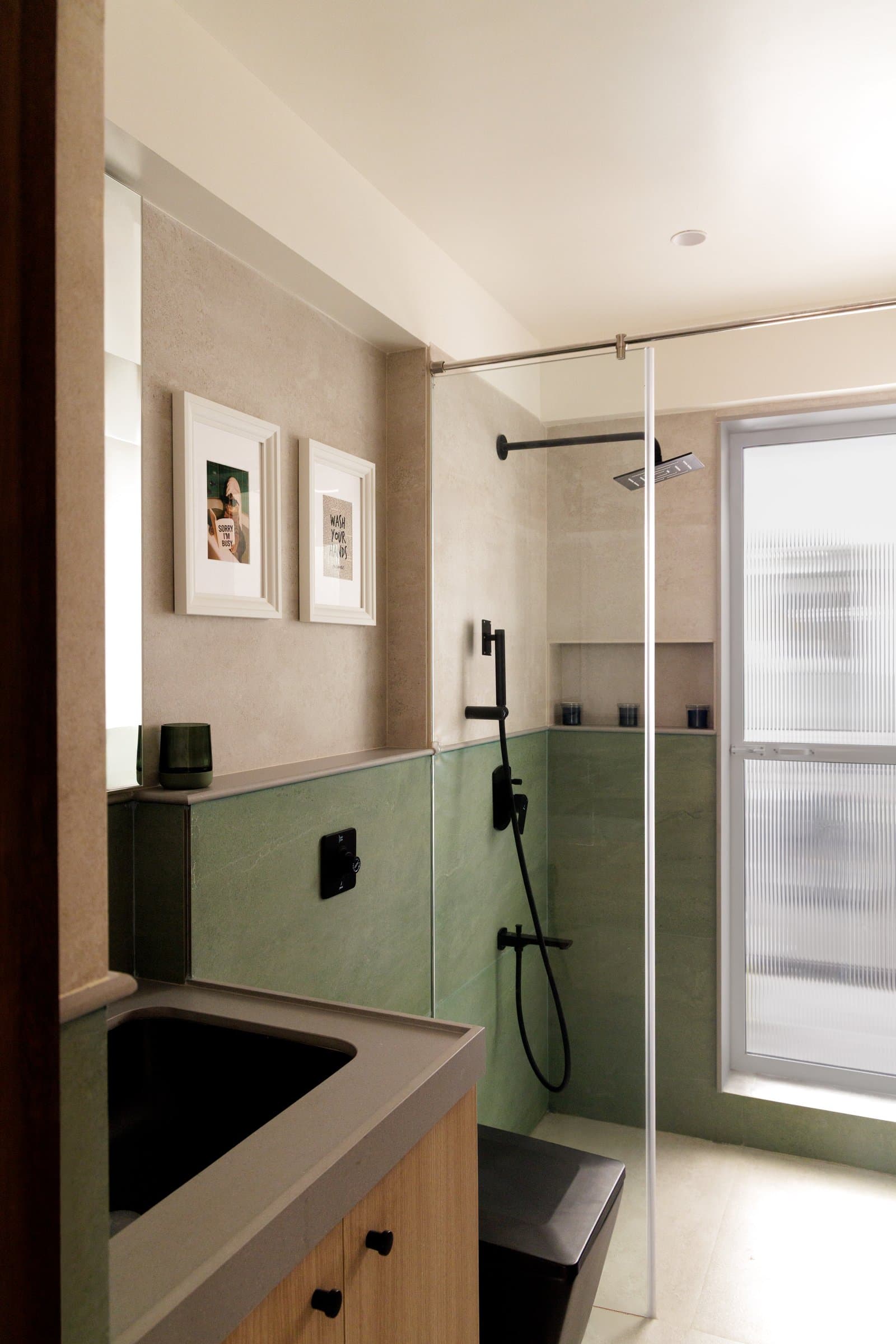The first bathroom, where sage-green tile rises to dado height around the wet zone