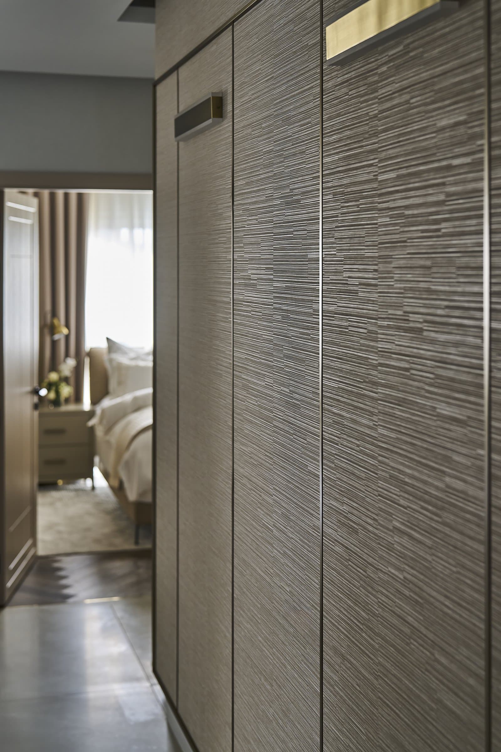 Reeded wardrobe doors in pewter mark the threshold between dressing and rest in the master suite
