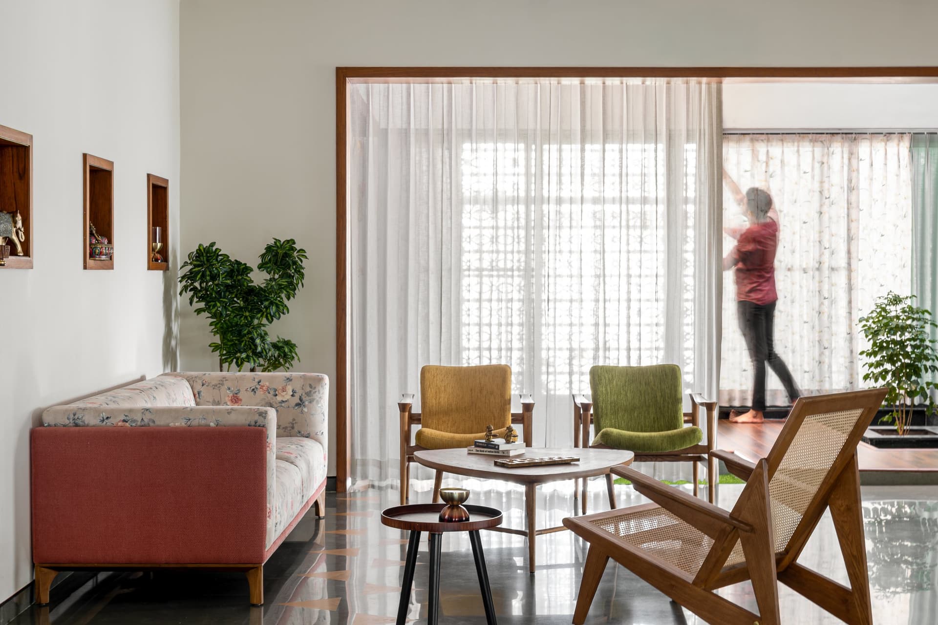 Recessed niches and filtered jaali light animate the living room through the course of the day