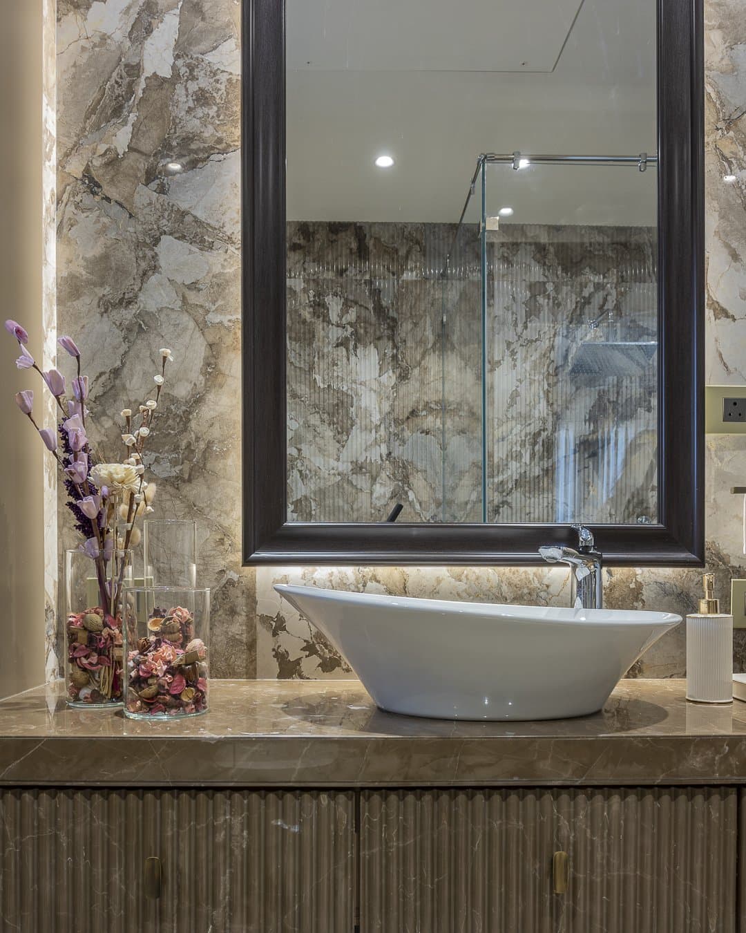 Veined stone and a fluted vanity base in one of the home's bathrooms