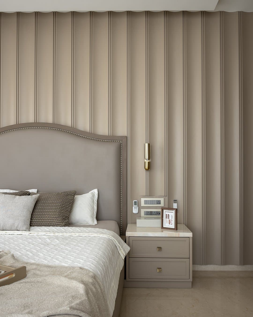 A second bedroom wrapped in full-height fluted panelling, achieving a cocoon-like softness