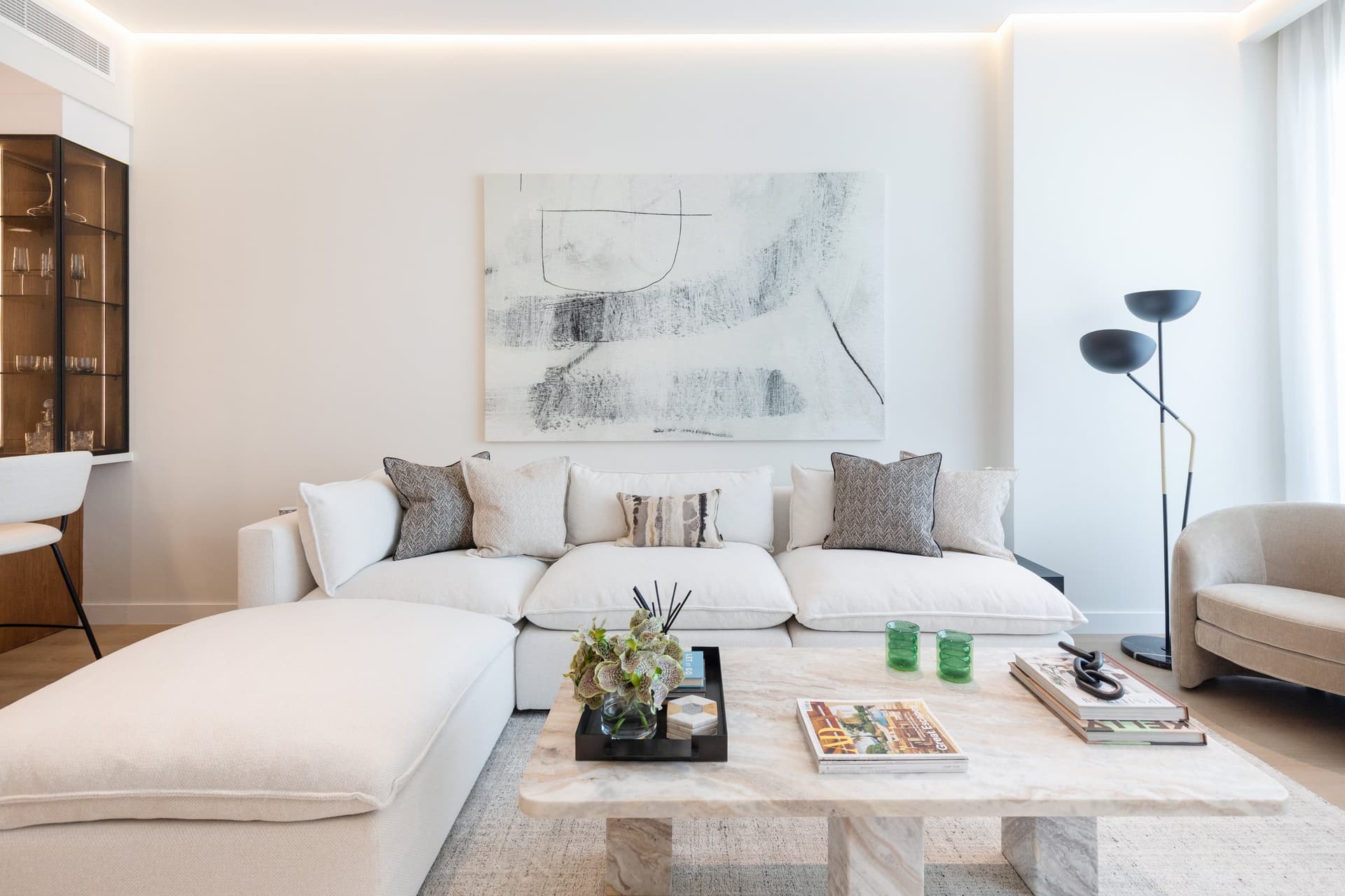 A travertine coffee table introduces precision against the softness of the boucle sectional