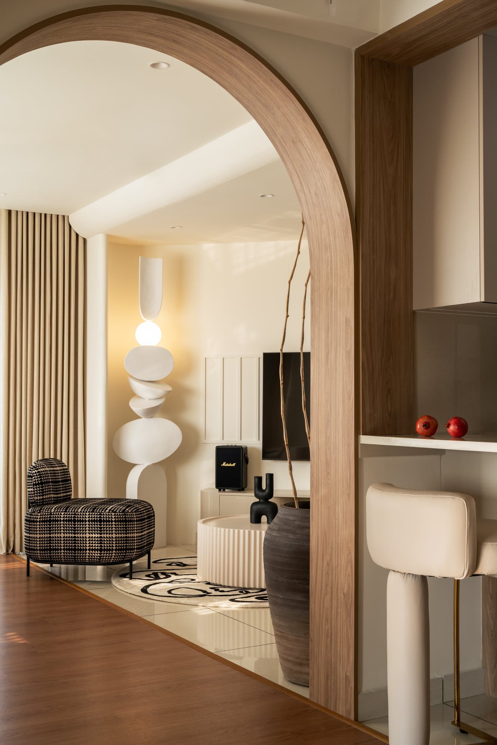 The arched wood-trimmed opening from the kitchen counter into the living room, threading continuity across functional zones