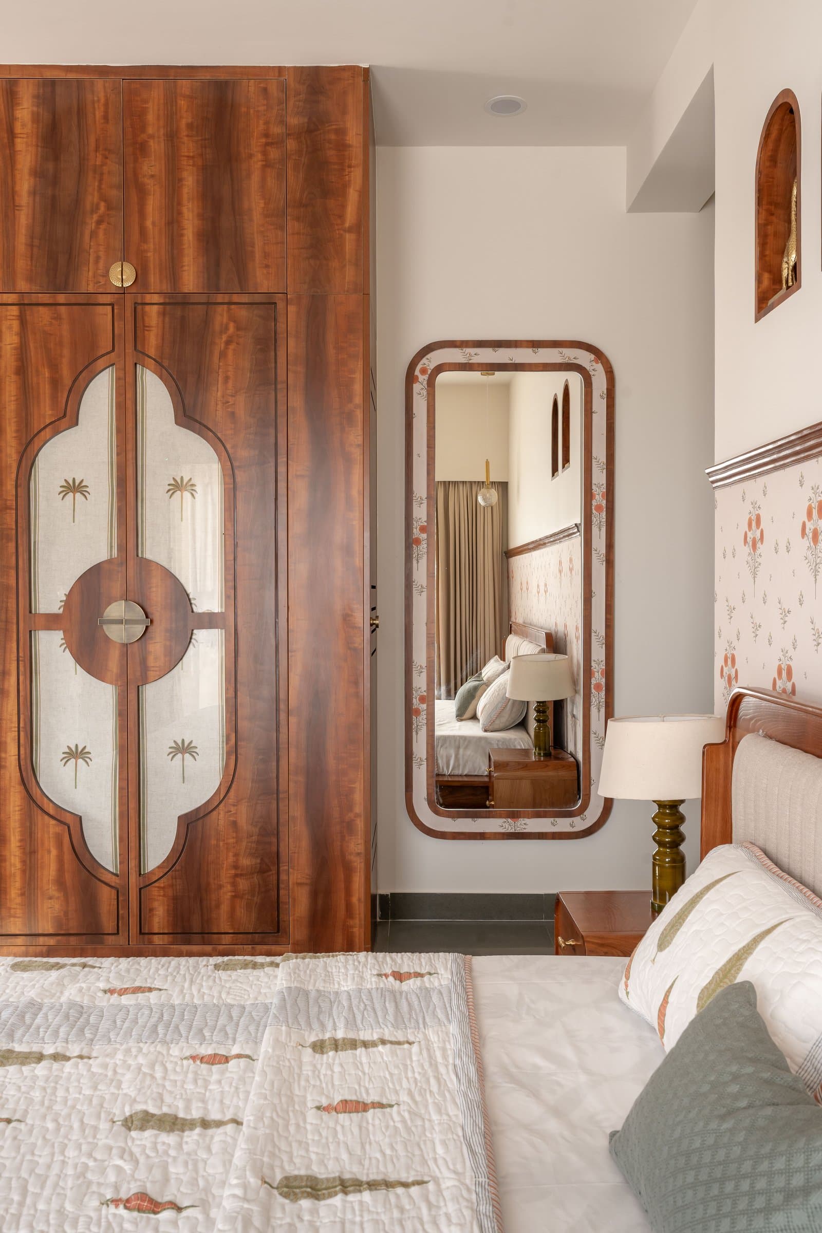 The dressing corner mirror, framing a small composition of bed, niches and pendant globe