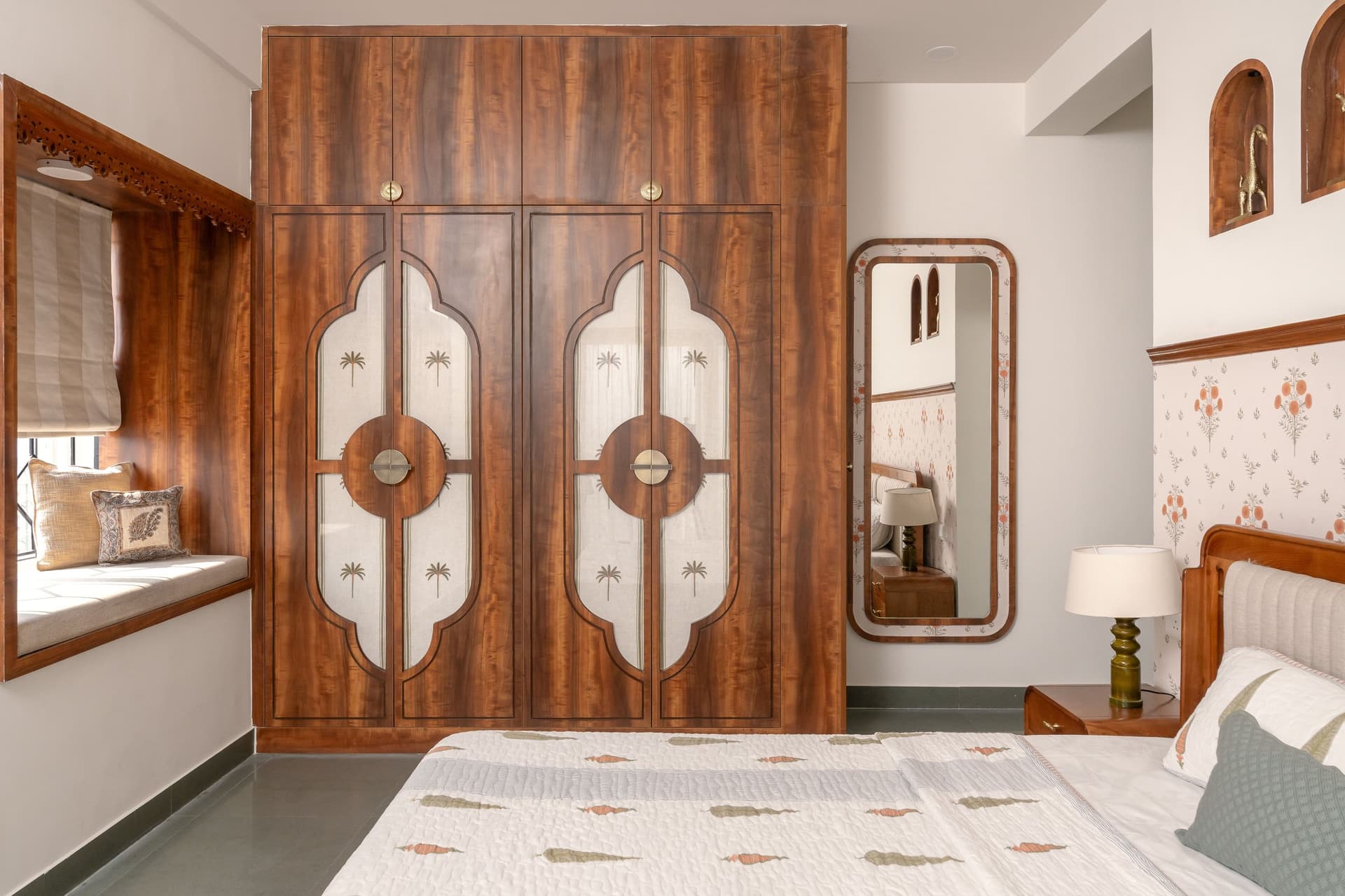 The wardrobe wall: cusped Mughal-style arches and stencilled linen panels turn storage into a cabinet of curiosities