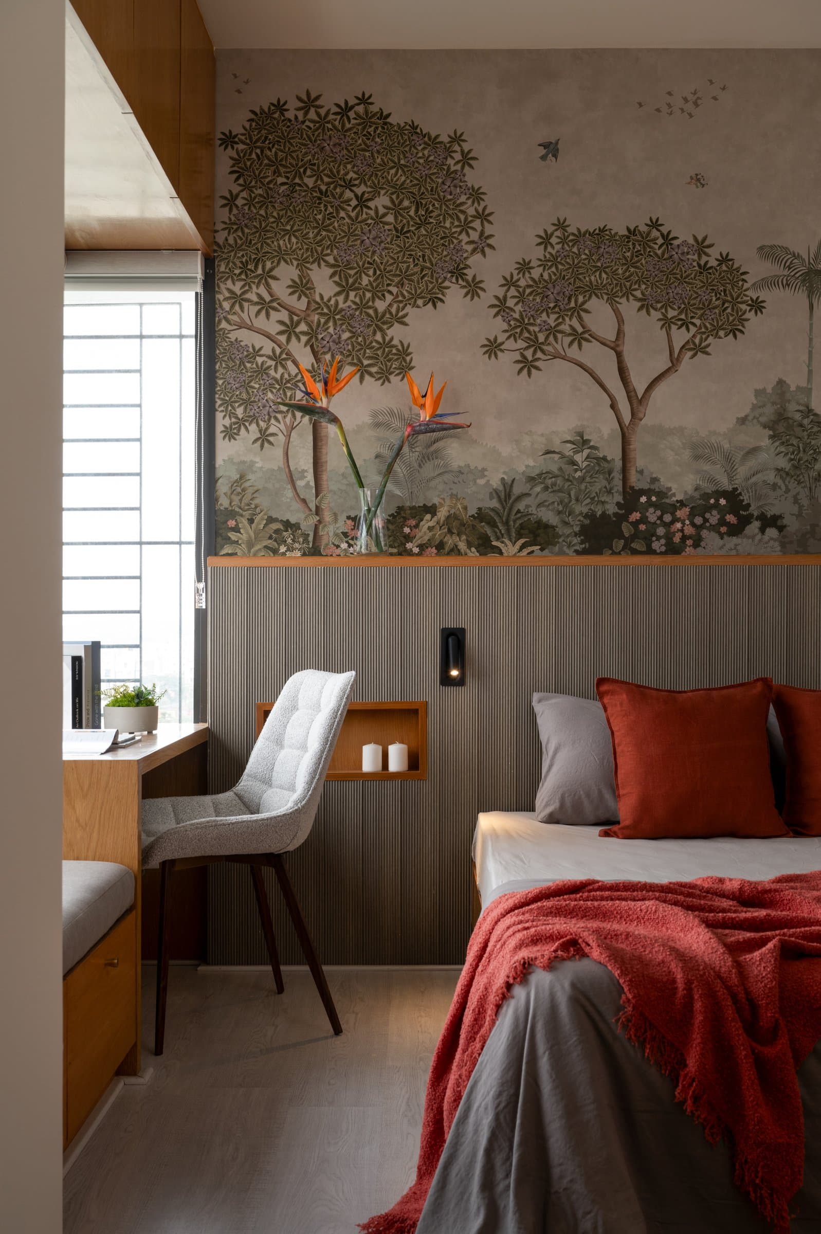 A closer view of the headboard wall, where reeded wood absorbs sound and folds storage and a candle niche into a single continuous surface