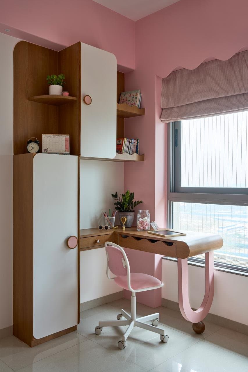 The same study seen empty: rounded doors, curved shelves, and a single circular pink pull