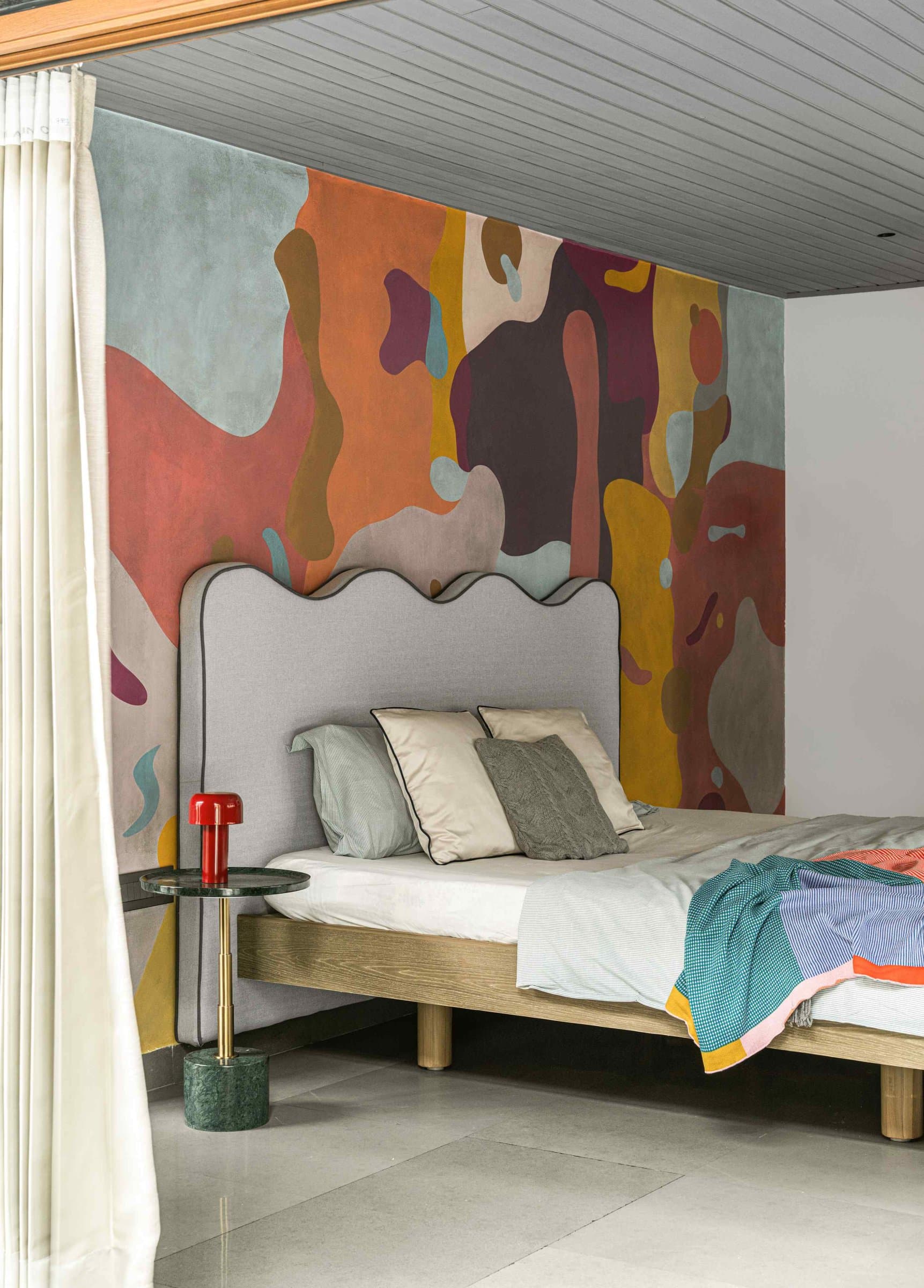 The first daughter's bedroom, where a hand-painted biomorphic mural wraps the headboard wall