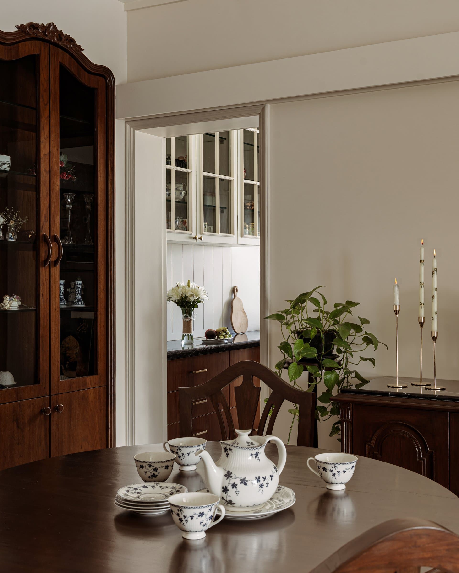 An inherited blue-and-white tea service on the dining table, with a framed glimpse into the kitchen's panelled backsplash and stone counter