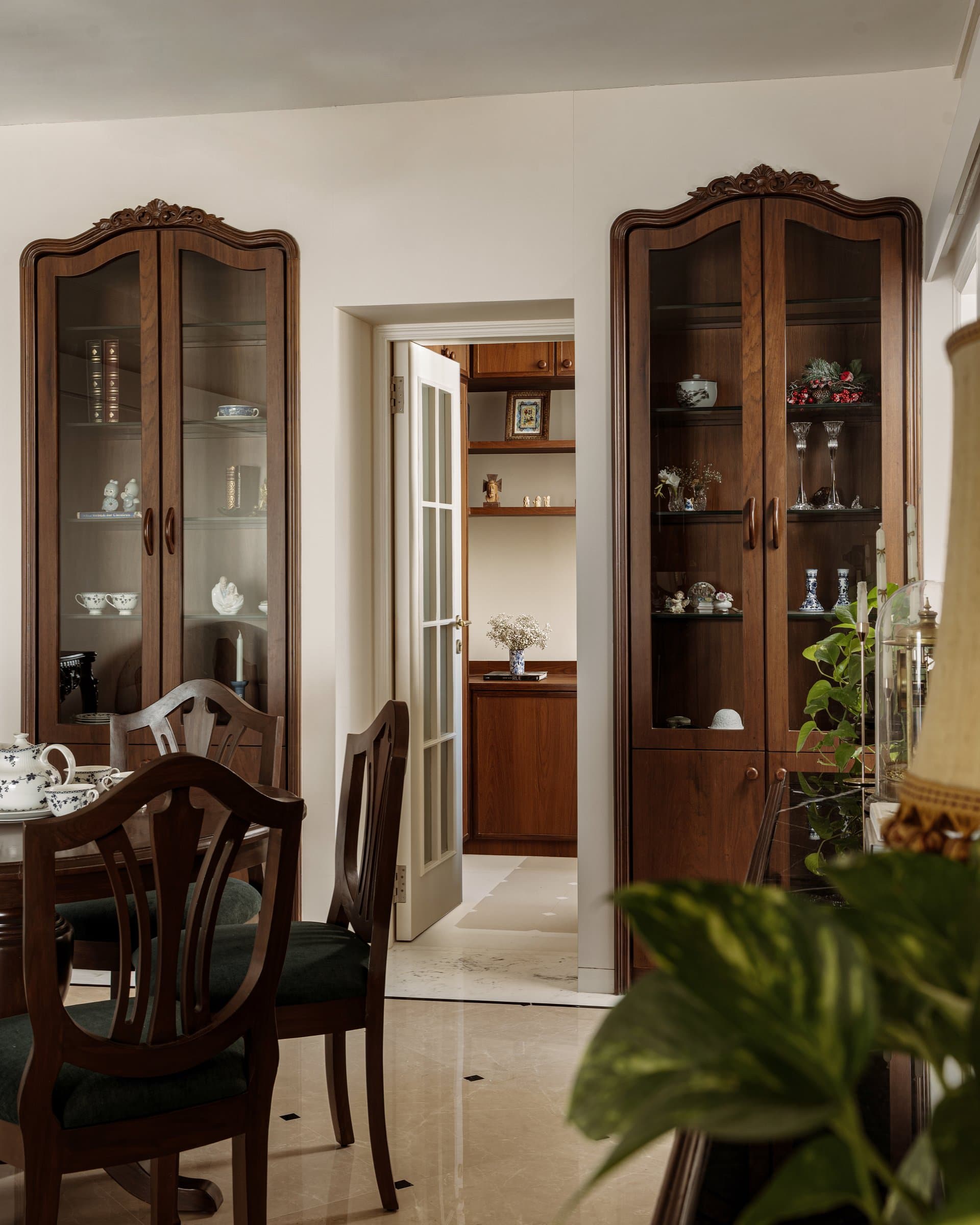 Seen from the opposite side, the dining room functions as both destination and connector, opening to an inner zone and the kitchen beyond