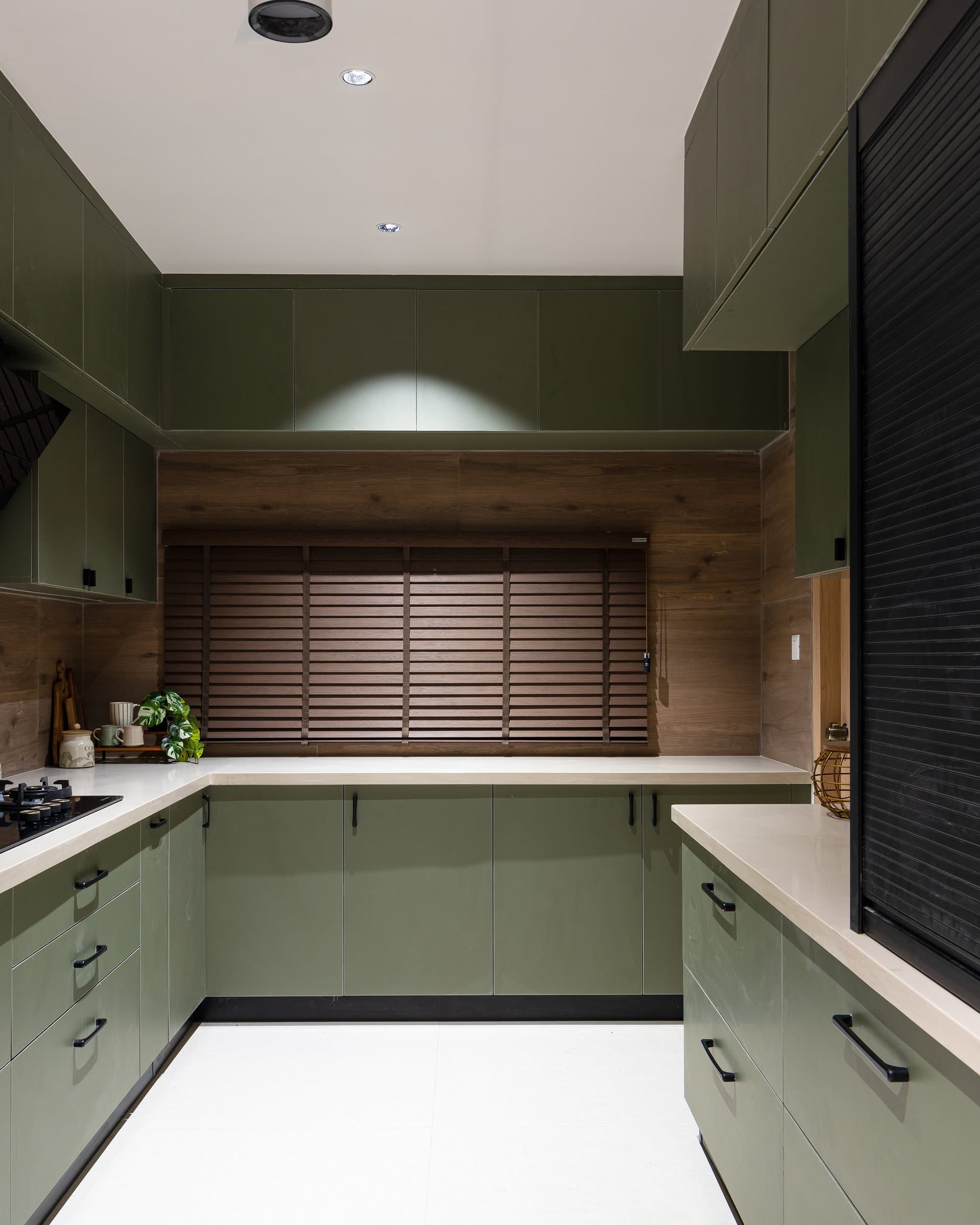Inside the kitchen, a louvered wood panel introduces texture into an otherwise streamlined elevation