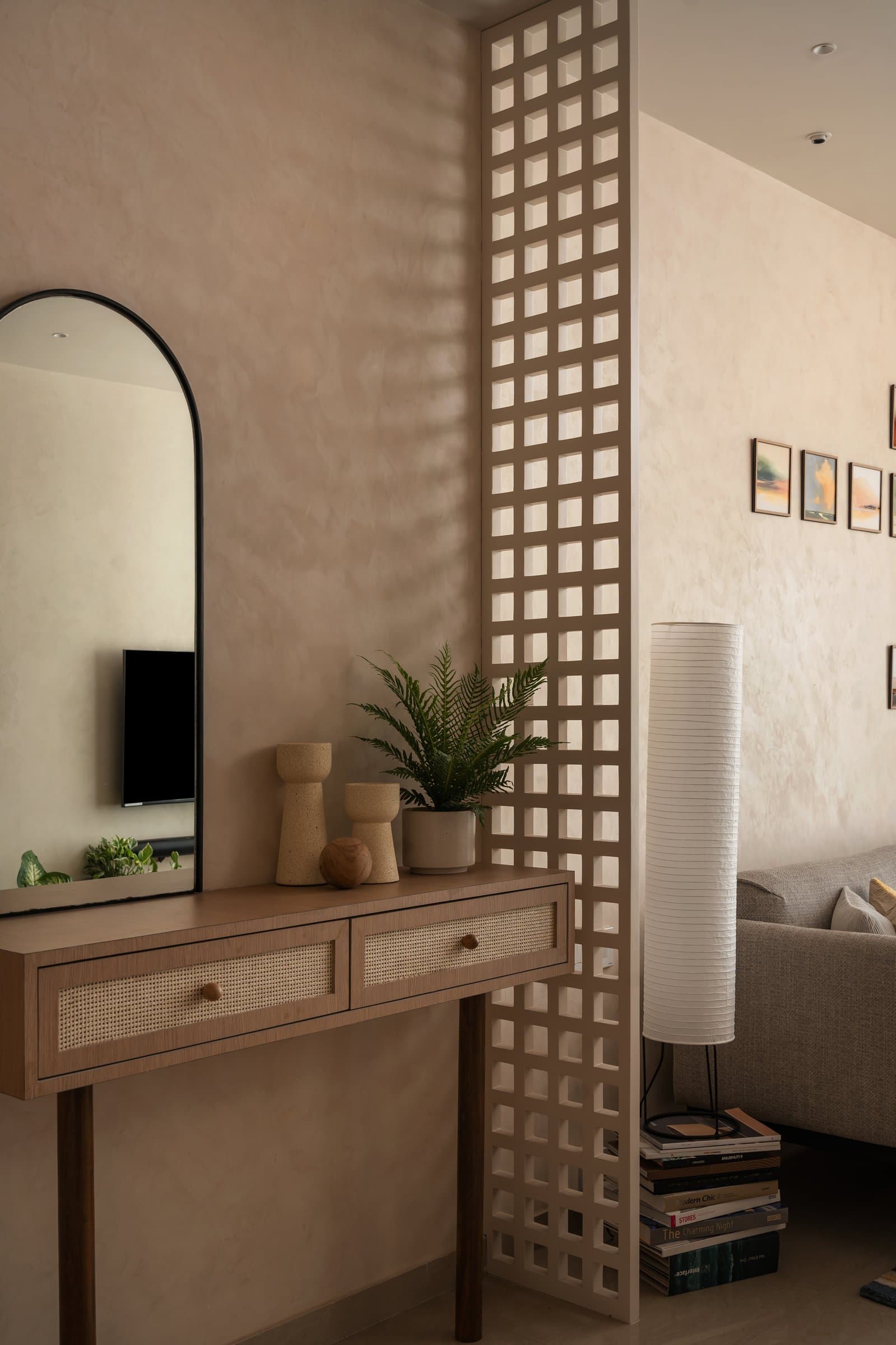 The wood lattice screen, read up close: divider, window and light fixture in a single gesture