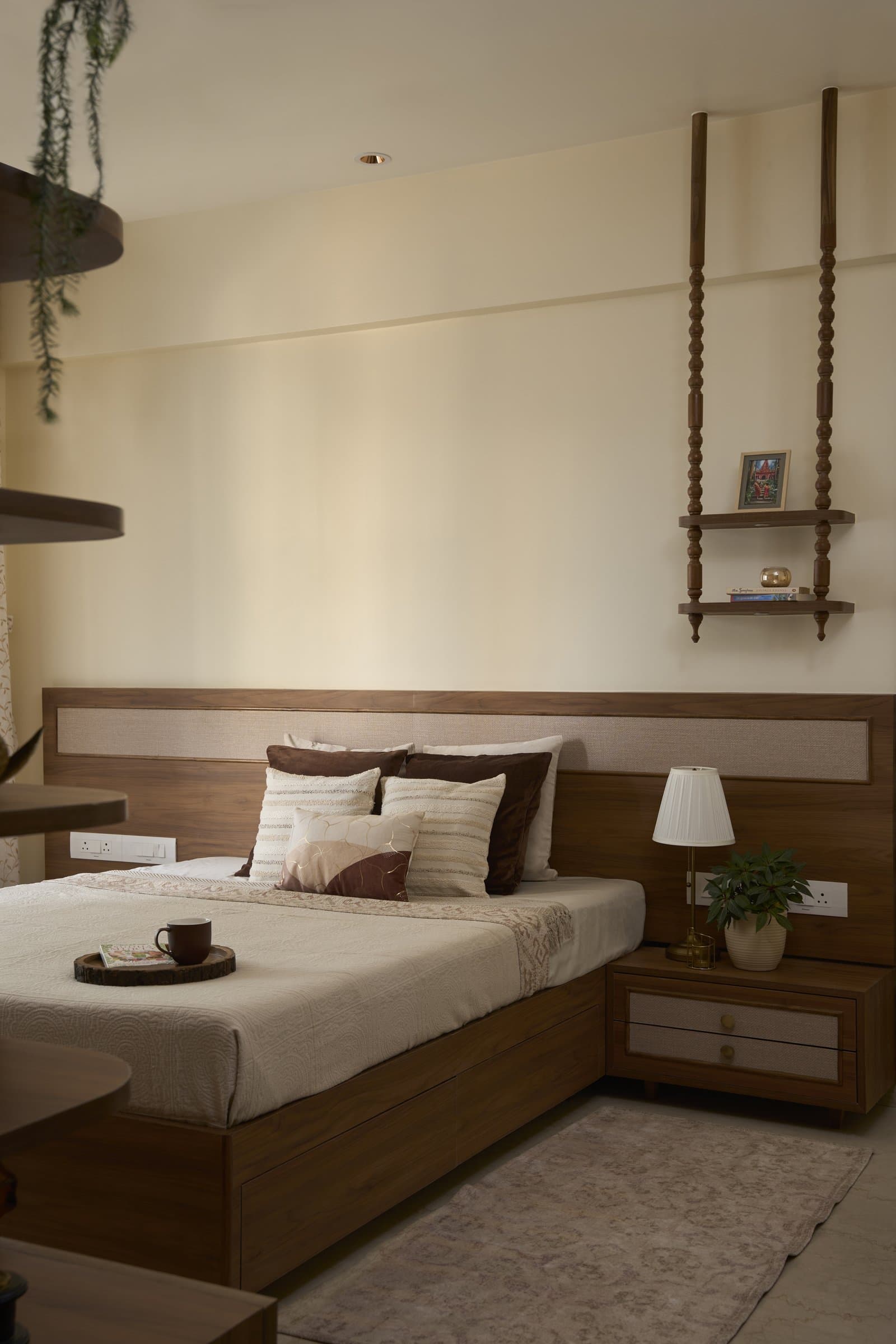 In the master bedroom, the material language continues uninterrupted, with a jute-panelled headboard running the full width of the wall