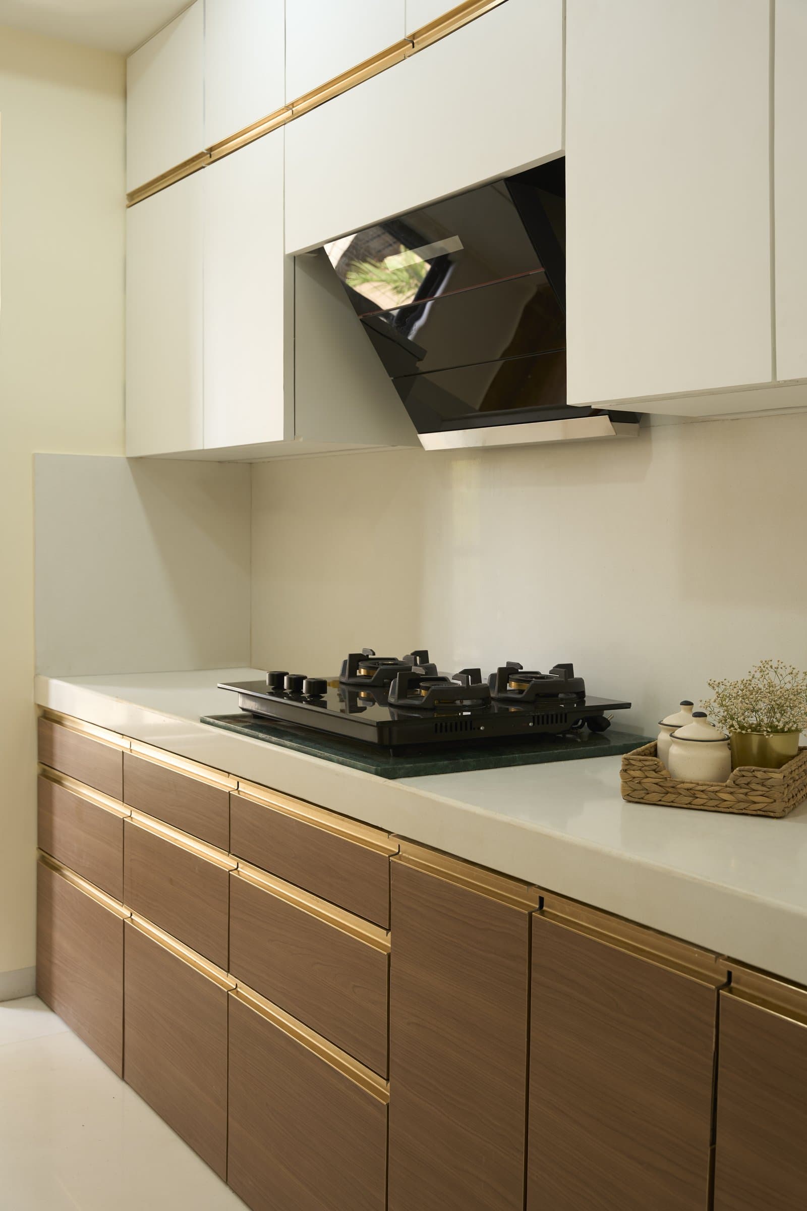 Along the cooking wall, darker wood drawers ground the room while lighter uppers keep it visually weightless