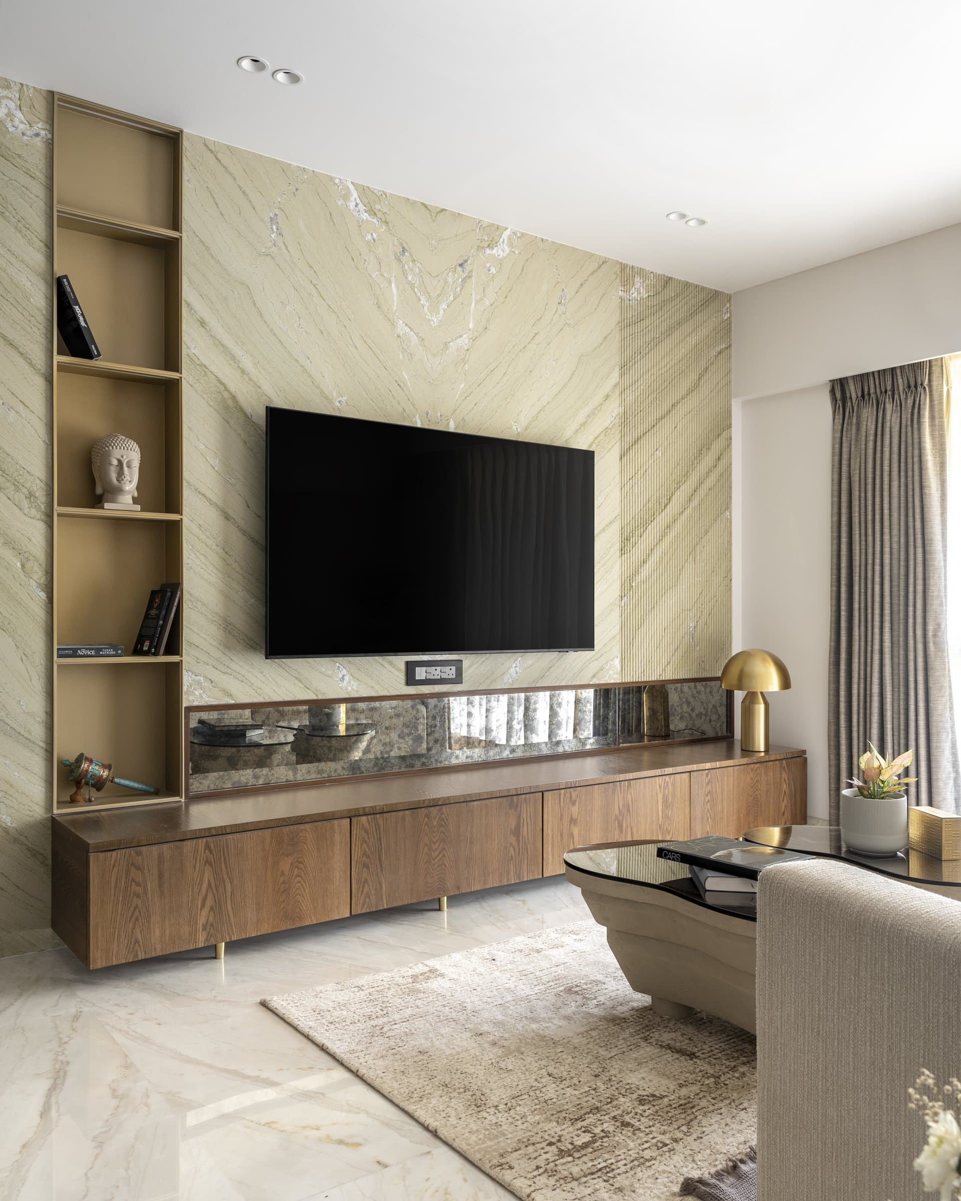 The media wall, where a panel of green-veined quartzite anchors a long oak credenza on slim brass feet