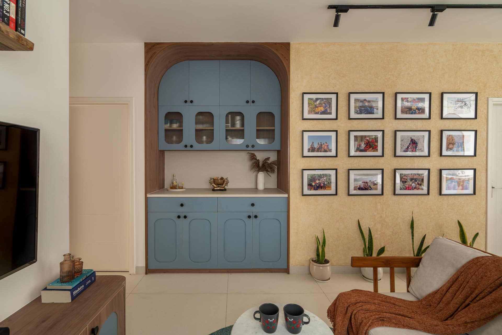 The crockery cabinet and travel-photo gallery wall, where family memory is given architectural weight