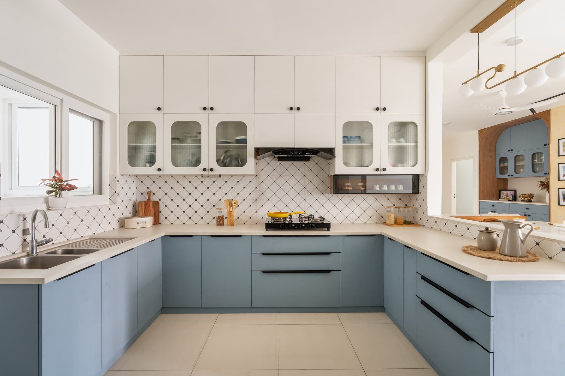 The kitchen in powder-blue cabinetry, with a diamond-patterned backsplash adding rhythm to the U-shaped layout