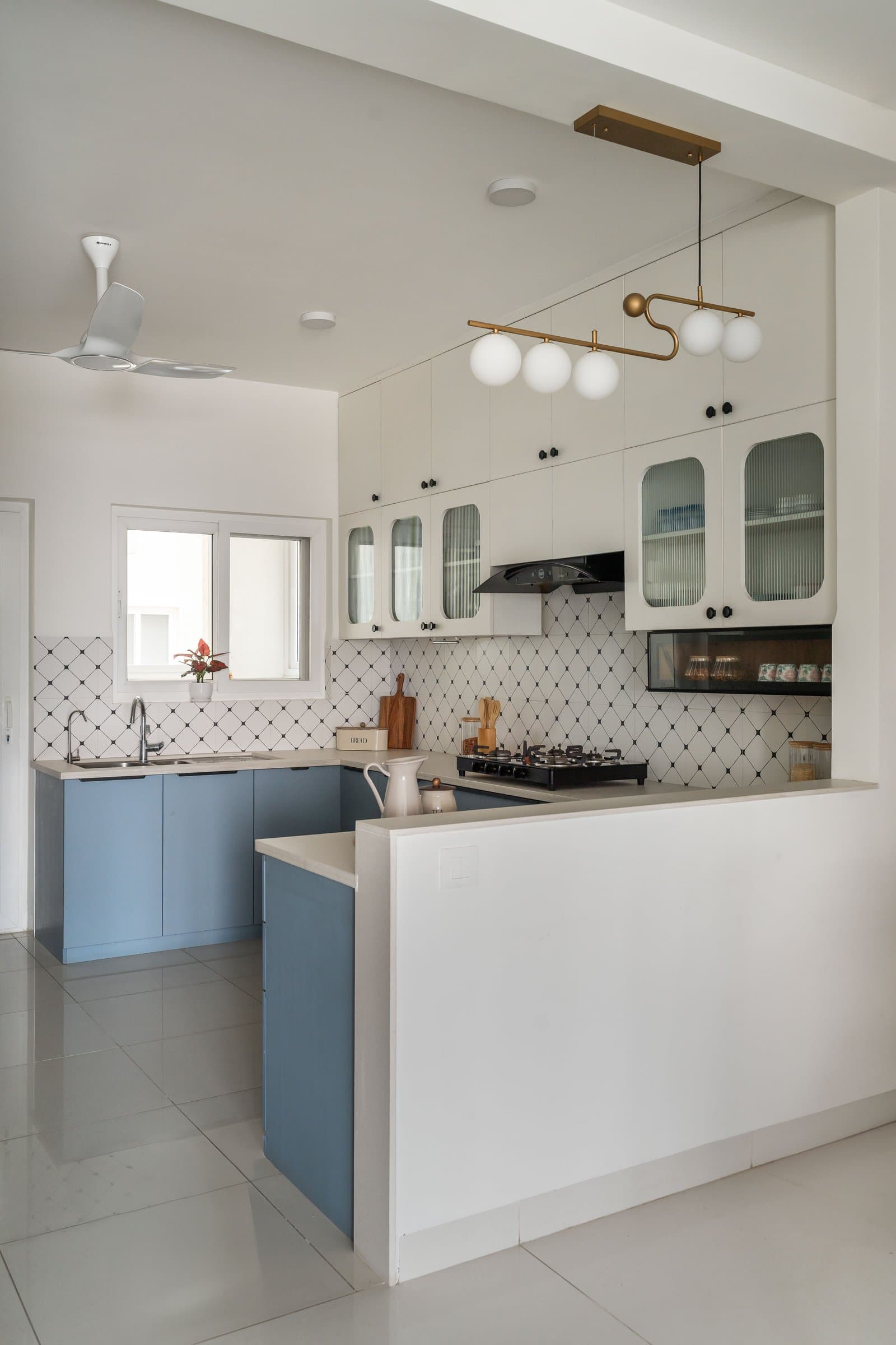 From another angle, the brass-and-globe pendant becomes the kitchen's single sculptural extravagance