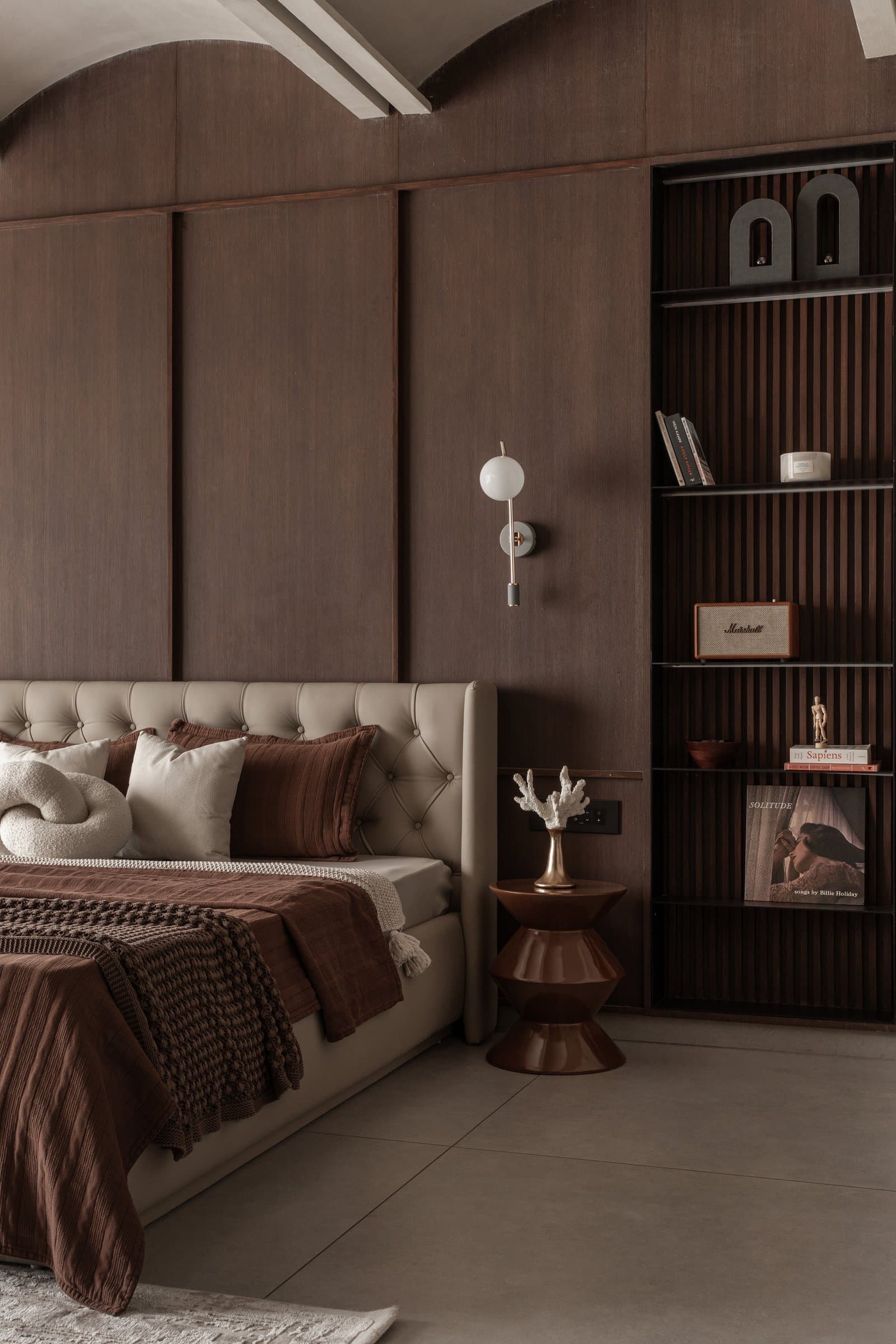 The slatted shelving unit beside the bed, where the family's books and collected objects are finally given room to be seen