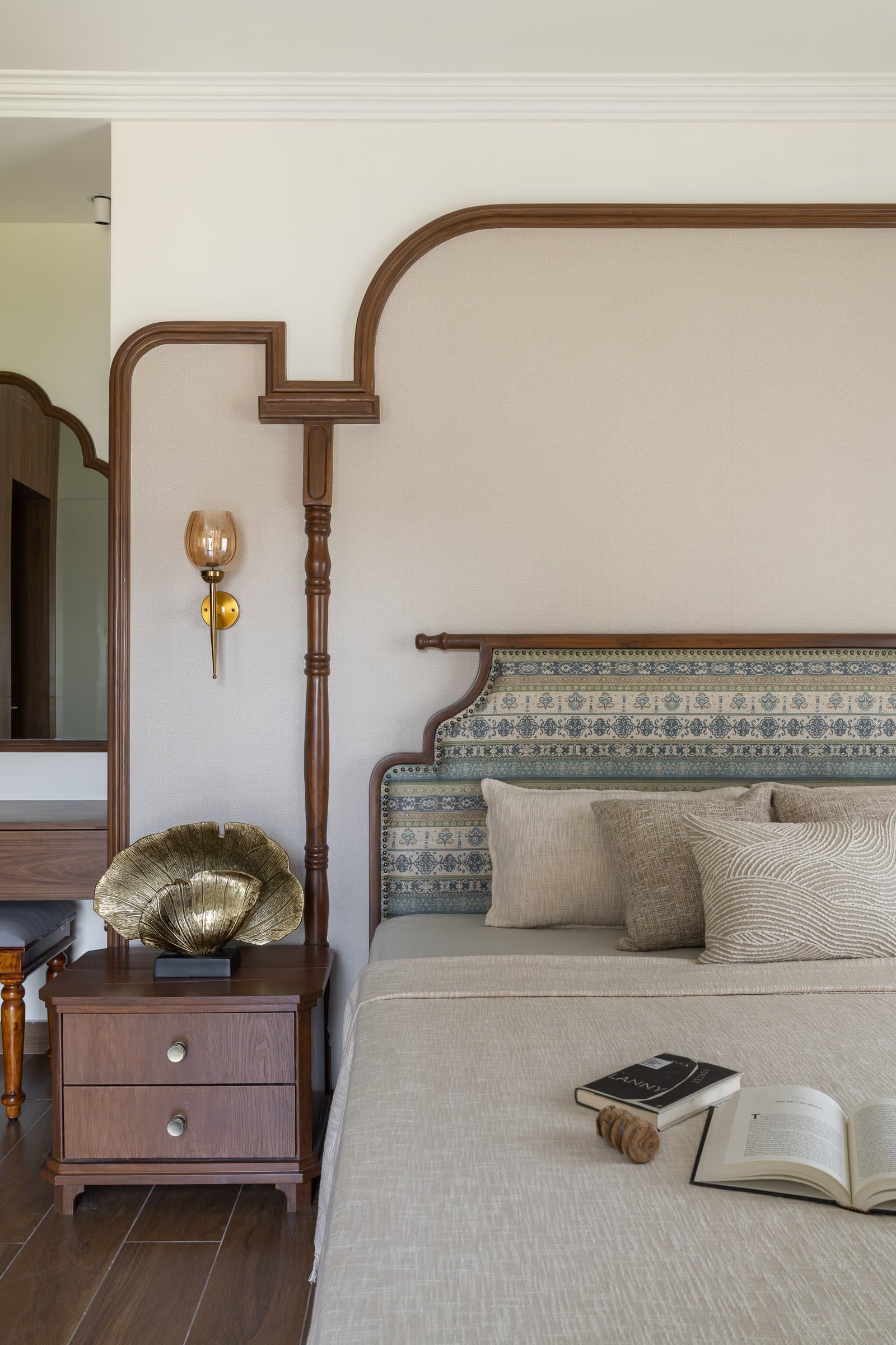 A closer view of the headboard, with its patterned panel, turned post, and amber-glass sconce
