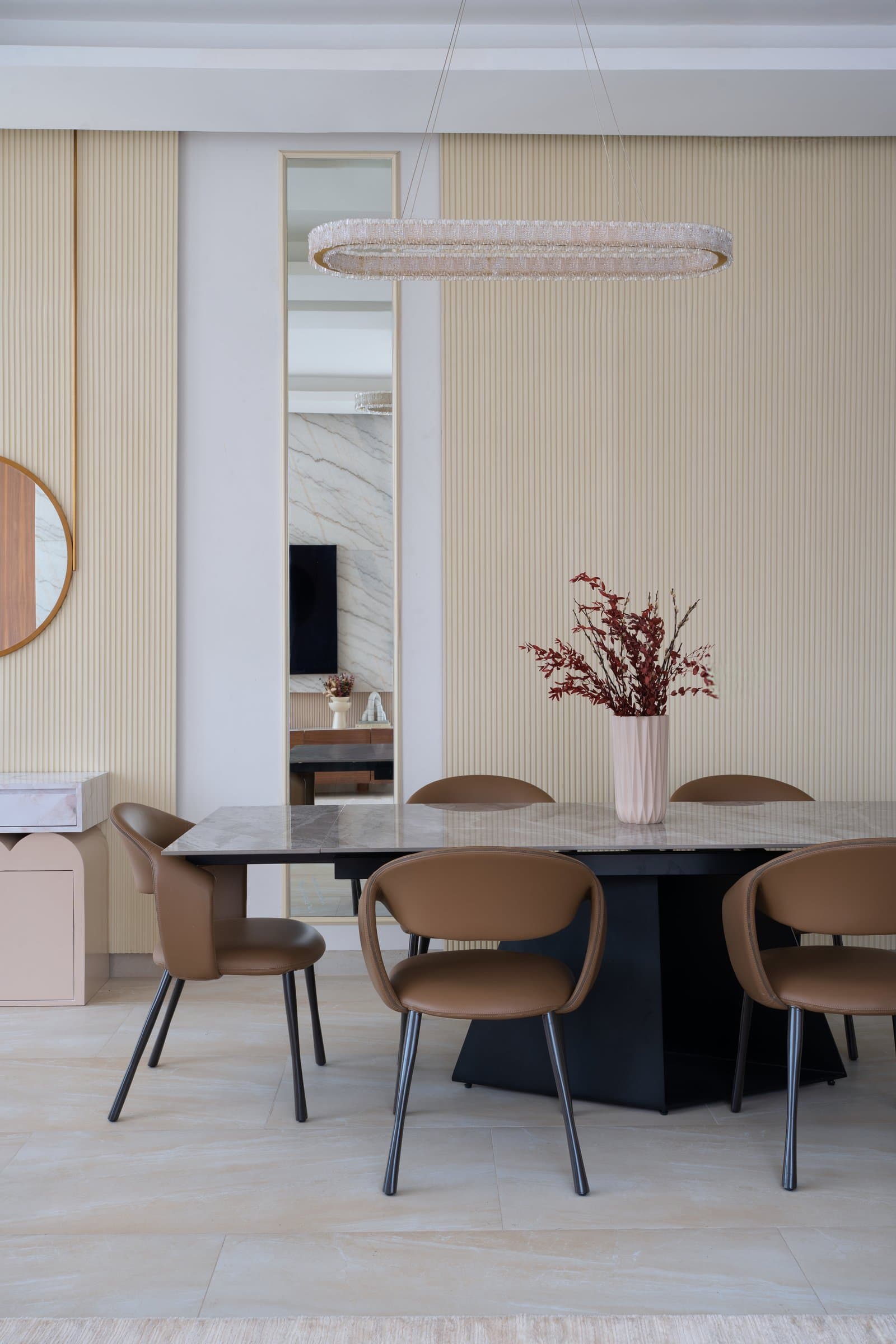 The full-height ribbed dining wall, framed by a slim mirrored insert that opens a sightline back into the living room