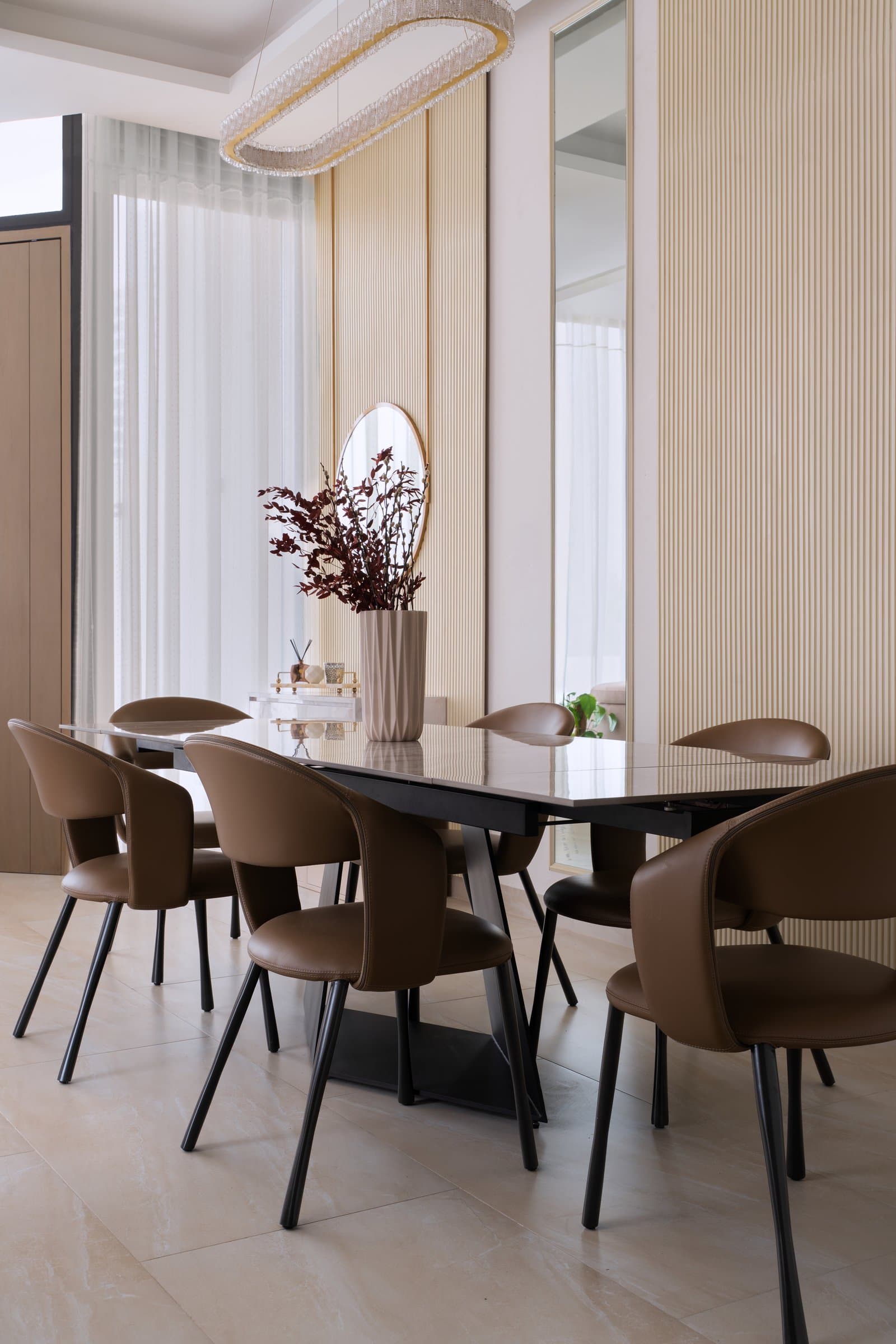 A study in calibrated texture: ribbed cream walls, fluted vase, and caramel leather chairs all within half a tonal step