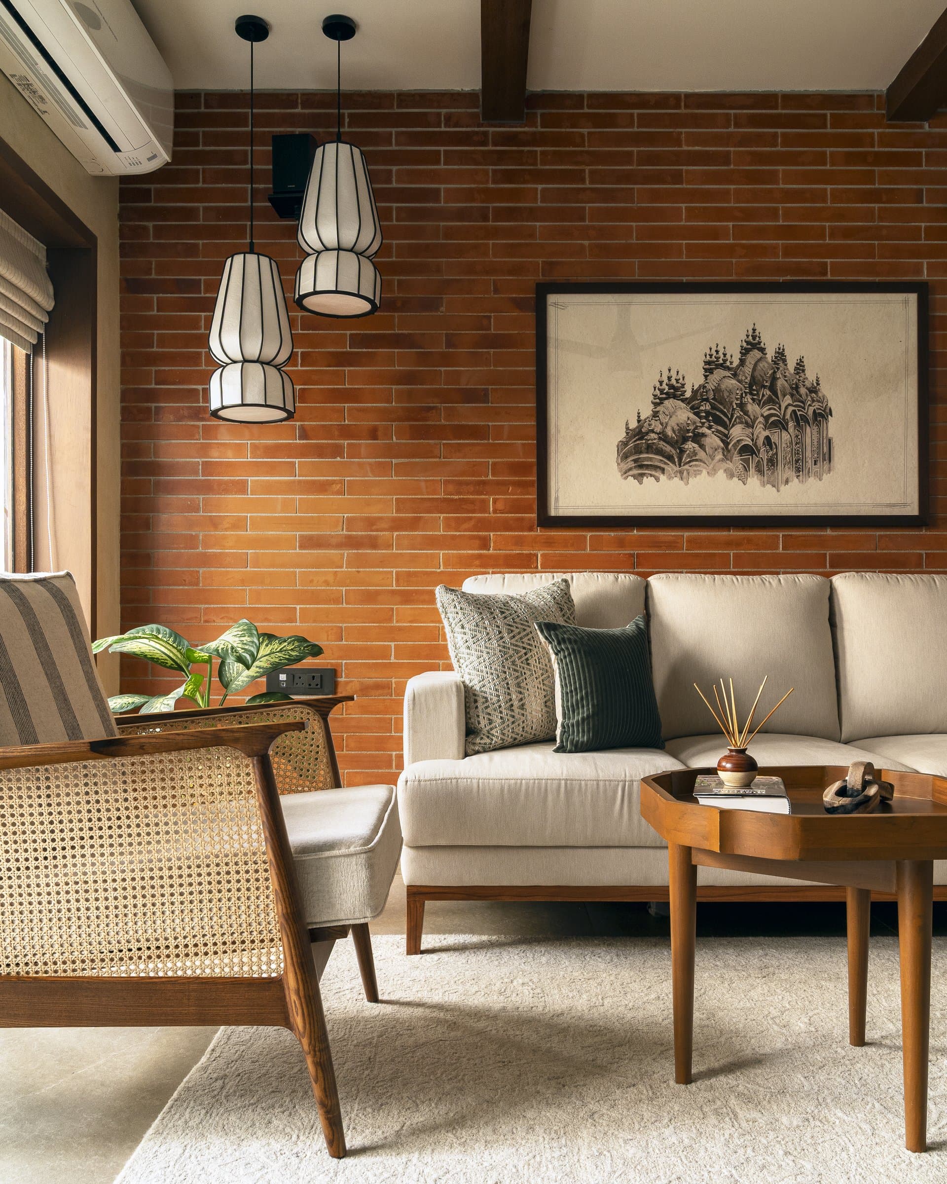 An exposed brick accent wall from Nuvocotto frames the seating, with a monochrome shikhara print acknowledging the temple-town heritage outside