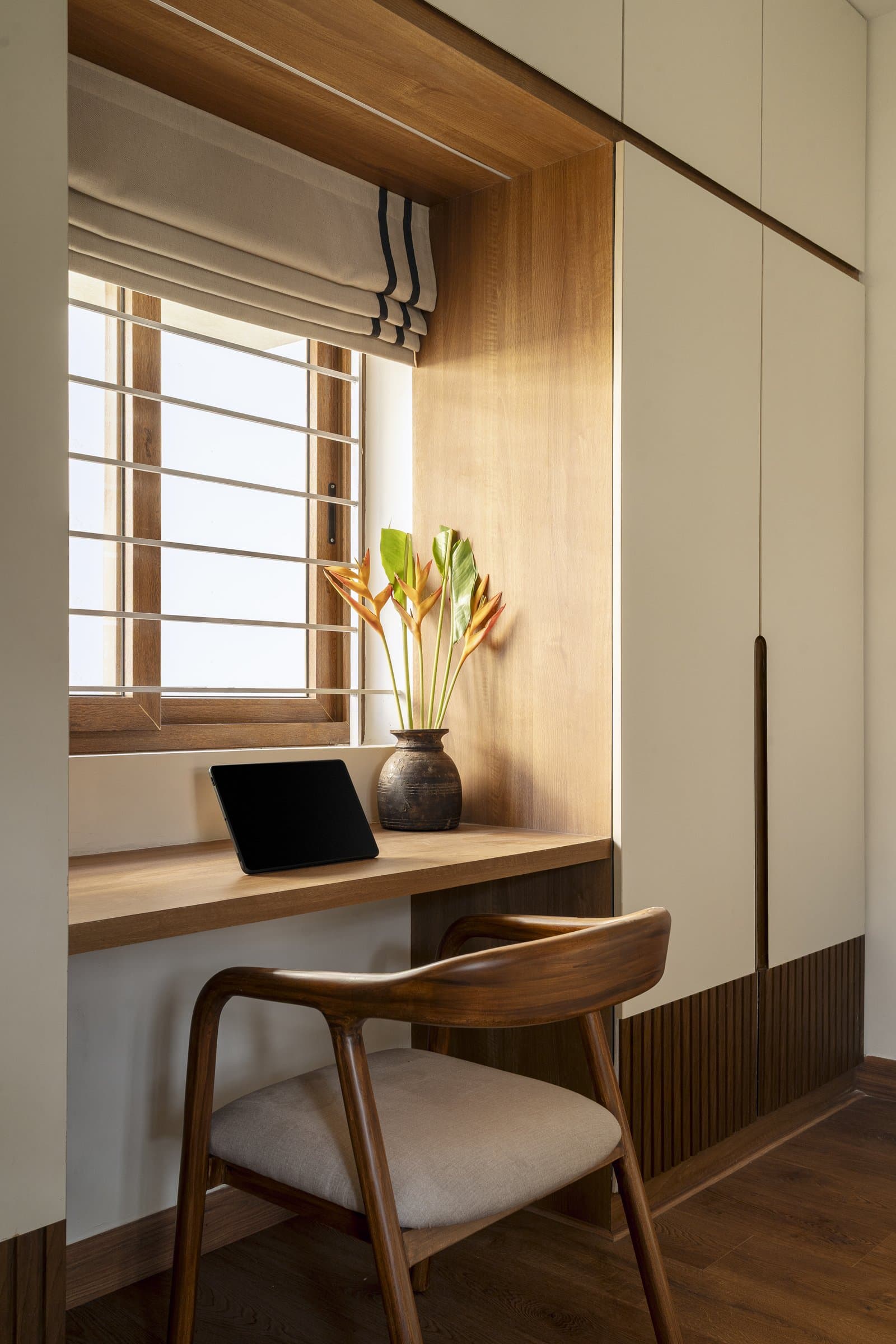 The built-in study nook within the guest bedroom, its desk cantilevered into a wood-lined alcove beneath the window