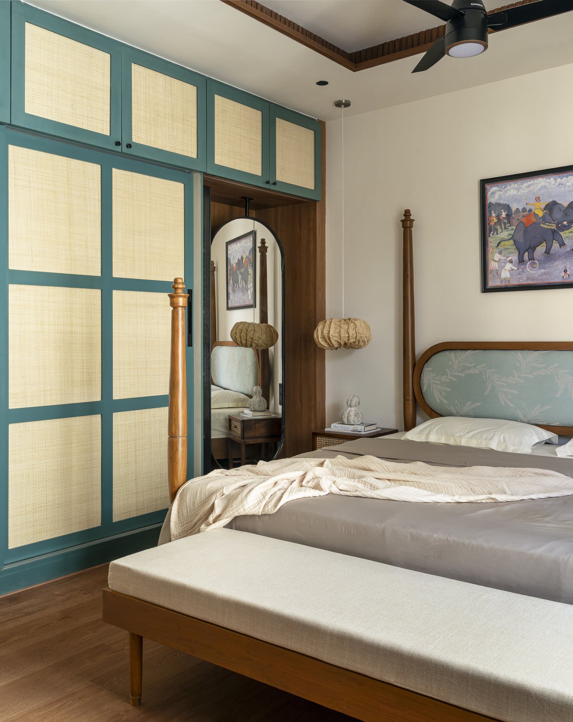 The wardrobe wall in the master, where bluish-green frames hold woven rattan panels, a contemporary refit of the old Madras cane almirah