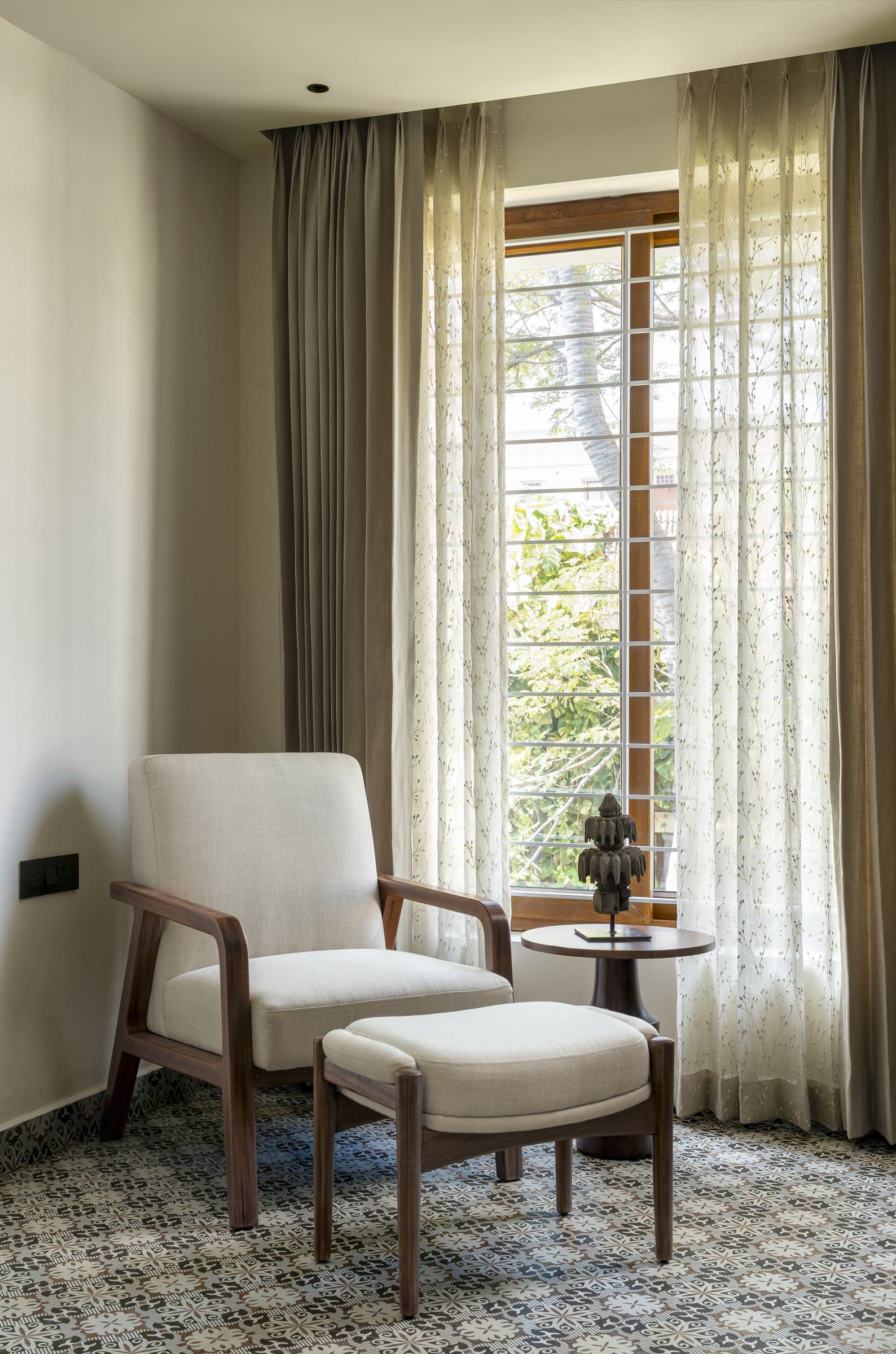 A lounge chair and ottoman by the study window, the home's most literal answer to the couple's brief for a place to come back to