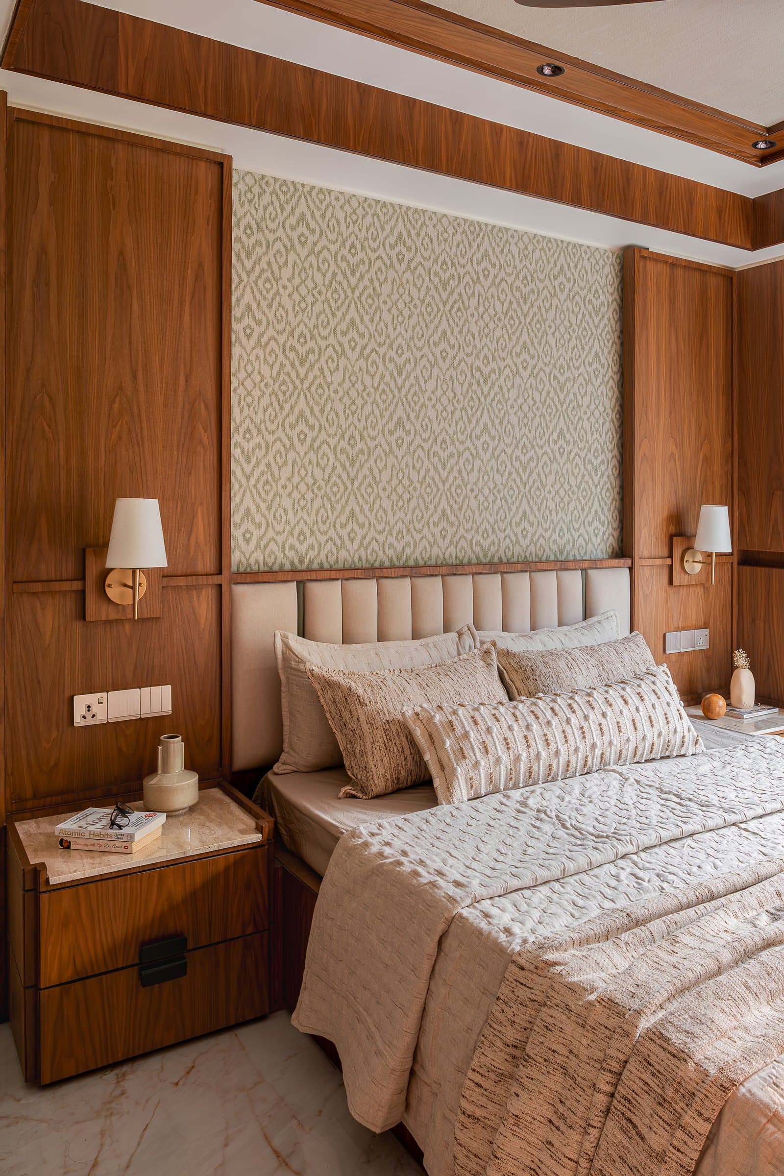 The master bedroom, where walnut wraps the headboard wall and ceiling into a single continuous plane