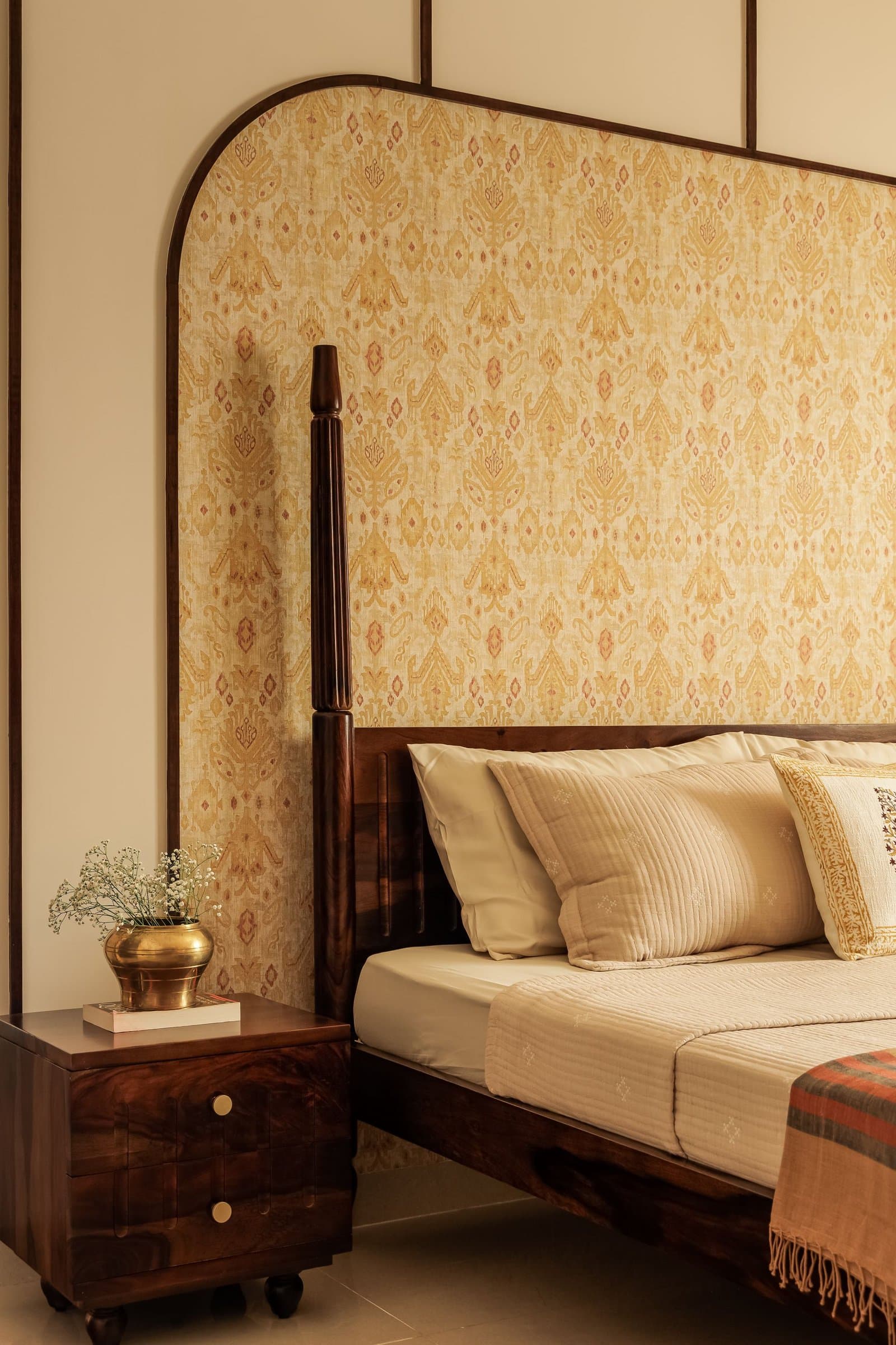 The headboard wall up close, where the patterned panel reads almost as a textile within its walnut frame