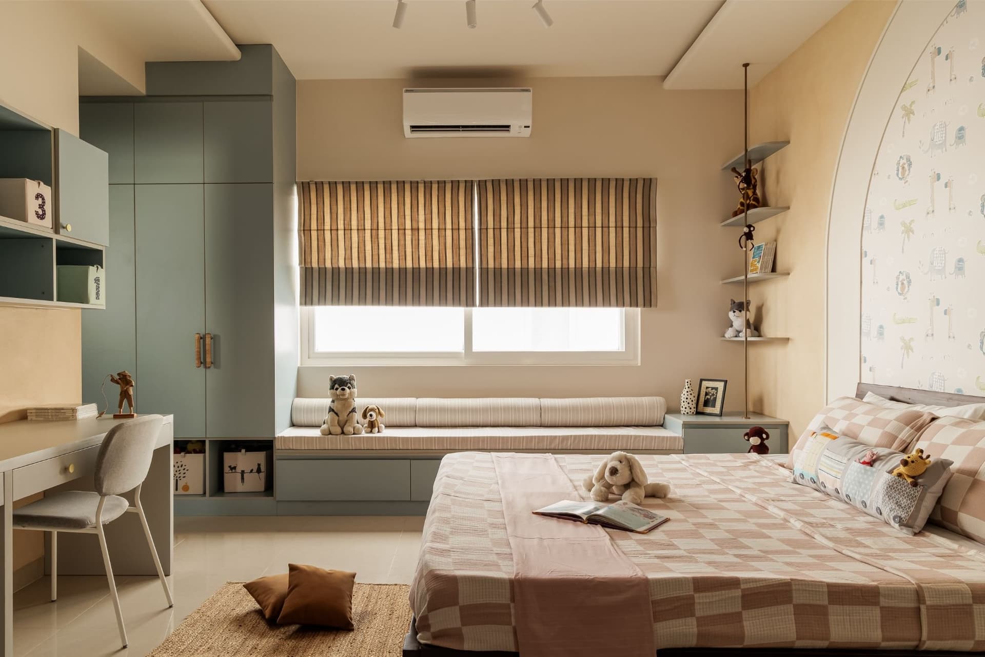 The children's room, with sage joinery, a built-in window seat, and a playful arched feature wall