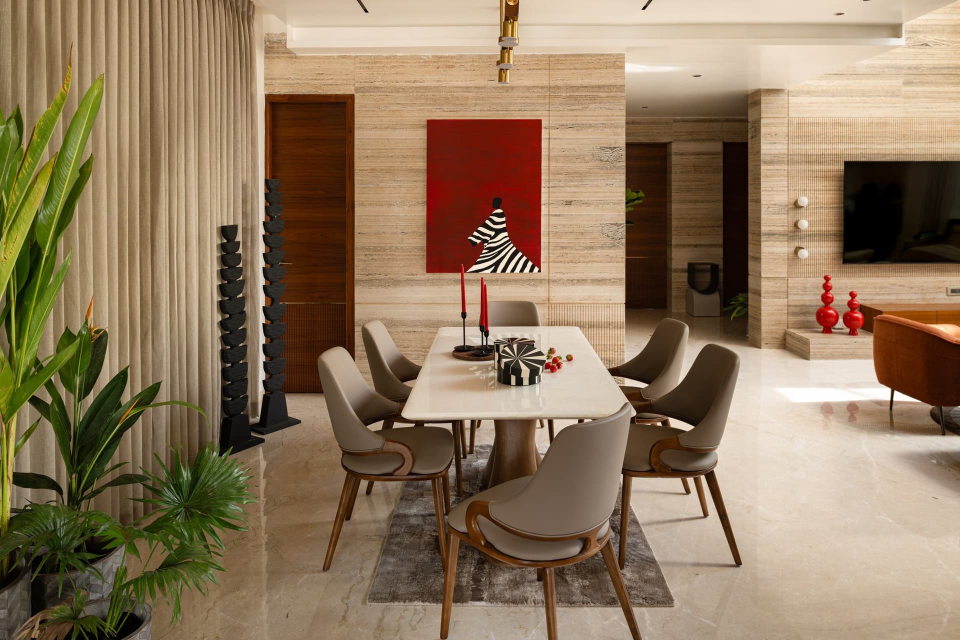 The dining room, anchored by a red canvas and flanked by tall black sculptural totems