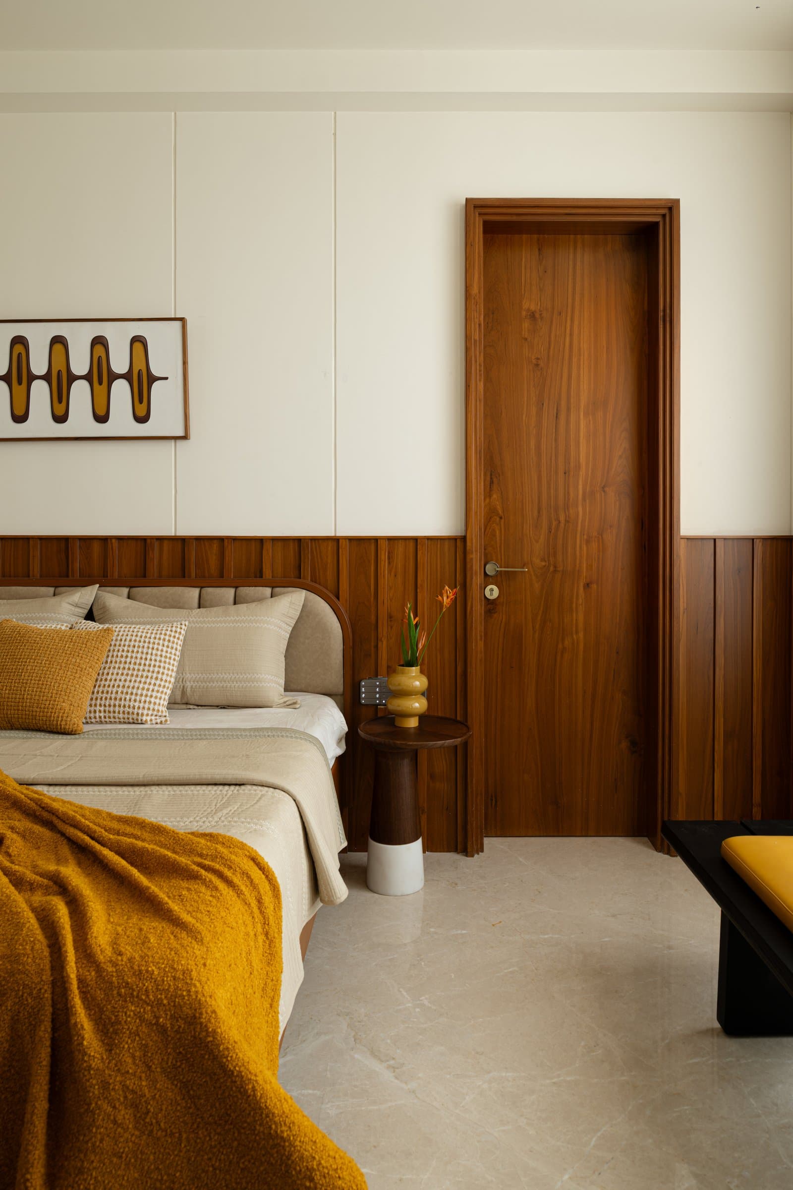 The guest bedroom, where a teak panelled dado meets a mid-century graphic above the bed