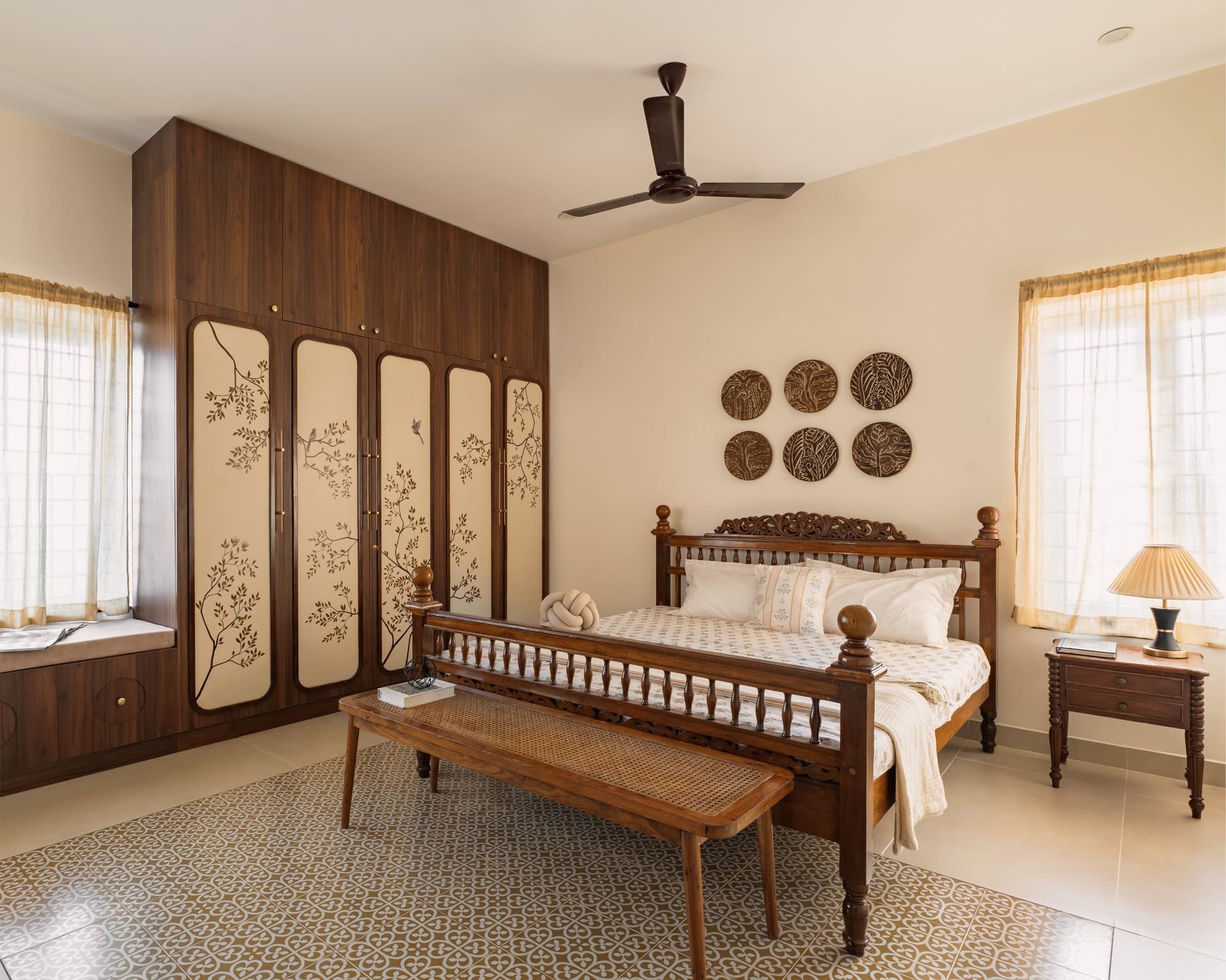 The master bedroom, where a spindled bed and a patterned cement-tile rug-shape extend the home's craft language